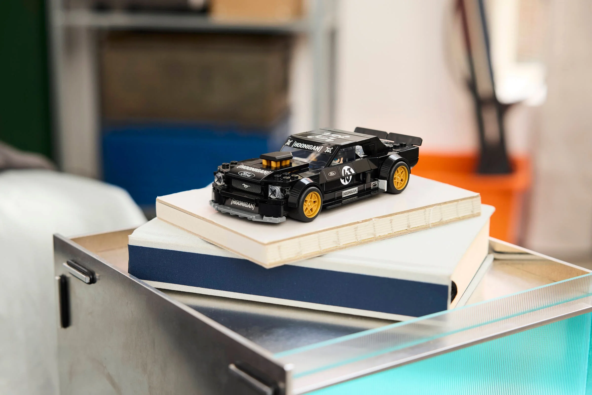 Modelul LEGO Ford Mustang Hoonicorn, negru cu detalii aurii, expus pe cărți. Mașină emblematică!