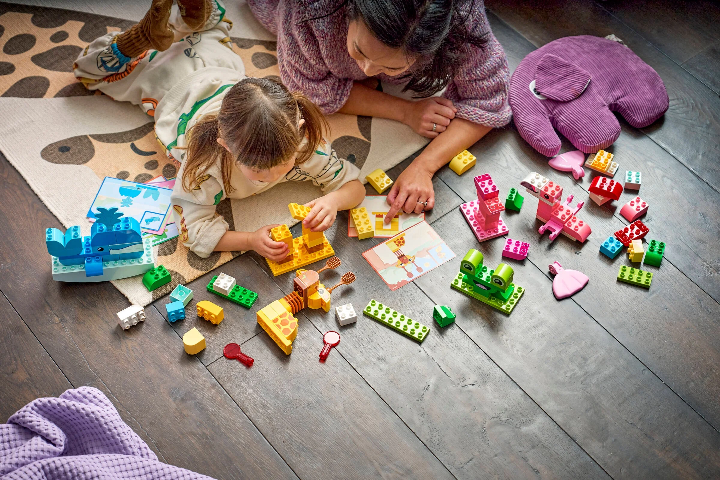 Copil și adult construind animale din cărămizi DUPLO. Joc creativ și distractiv pentru copii.