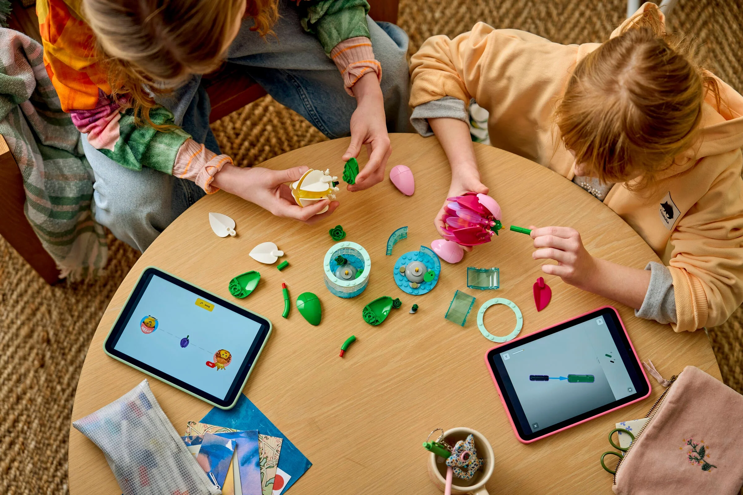 Copii construind setul LEGO Water Lilies urmând instrucțiuni digitale pe tabletă. Asamblare creativă și distractivă.