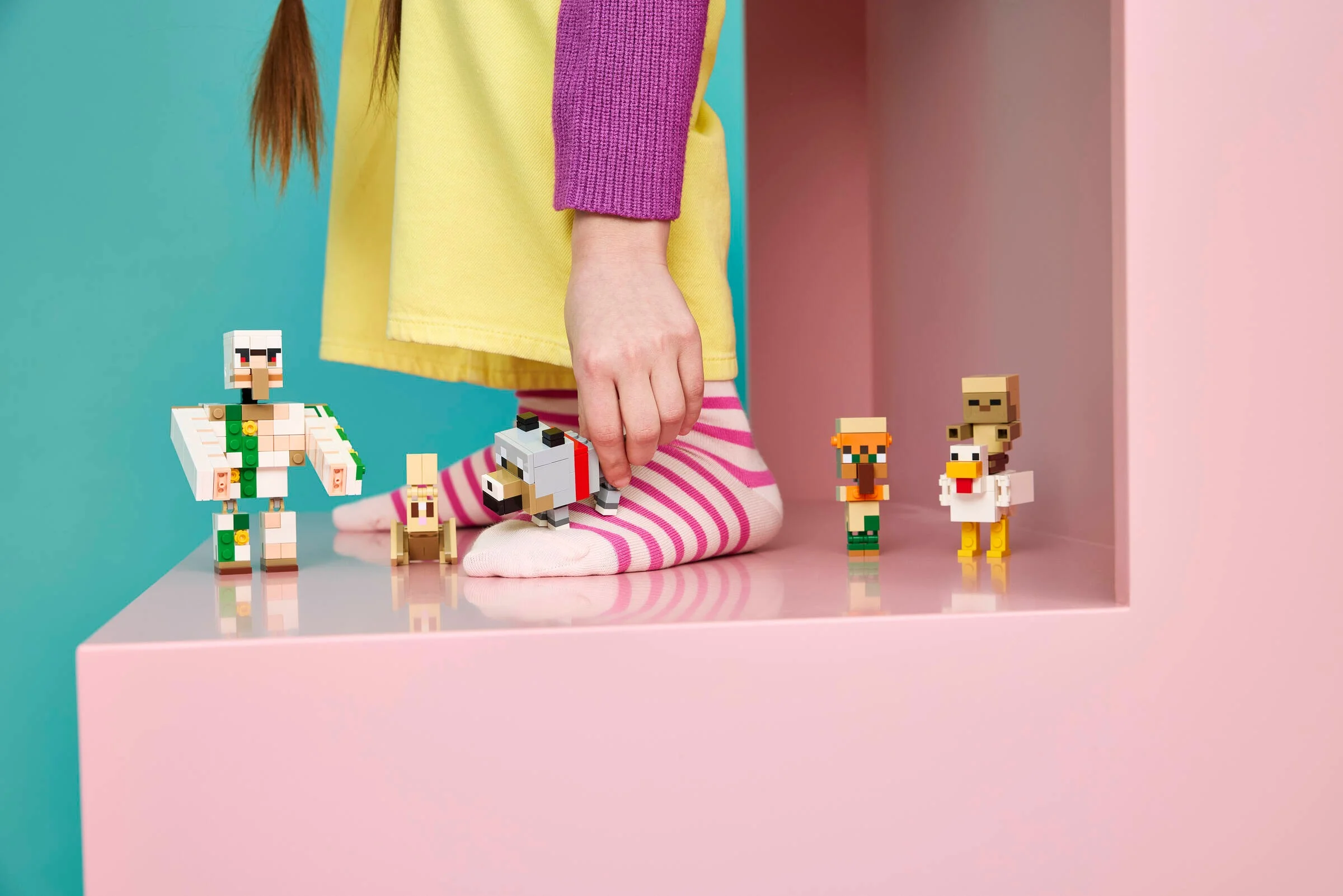 Copil se joacă cu setul LEGO Minecraft „Atacul jocheului de pui în deșert”.