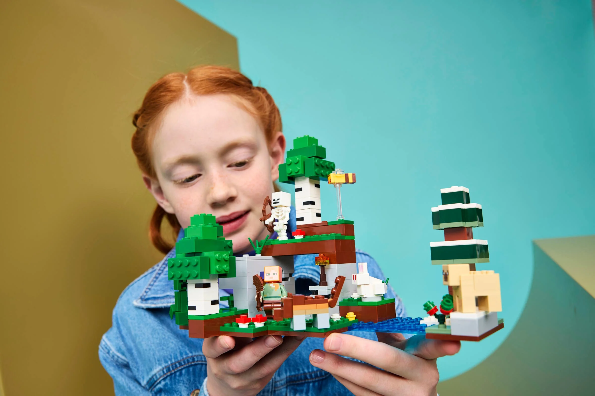 Fată construind setul LEGO Minecraft Aventură la prima noapte. Modelul e detaliat și colorat.