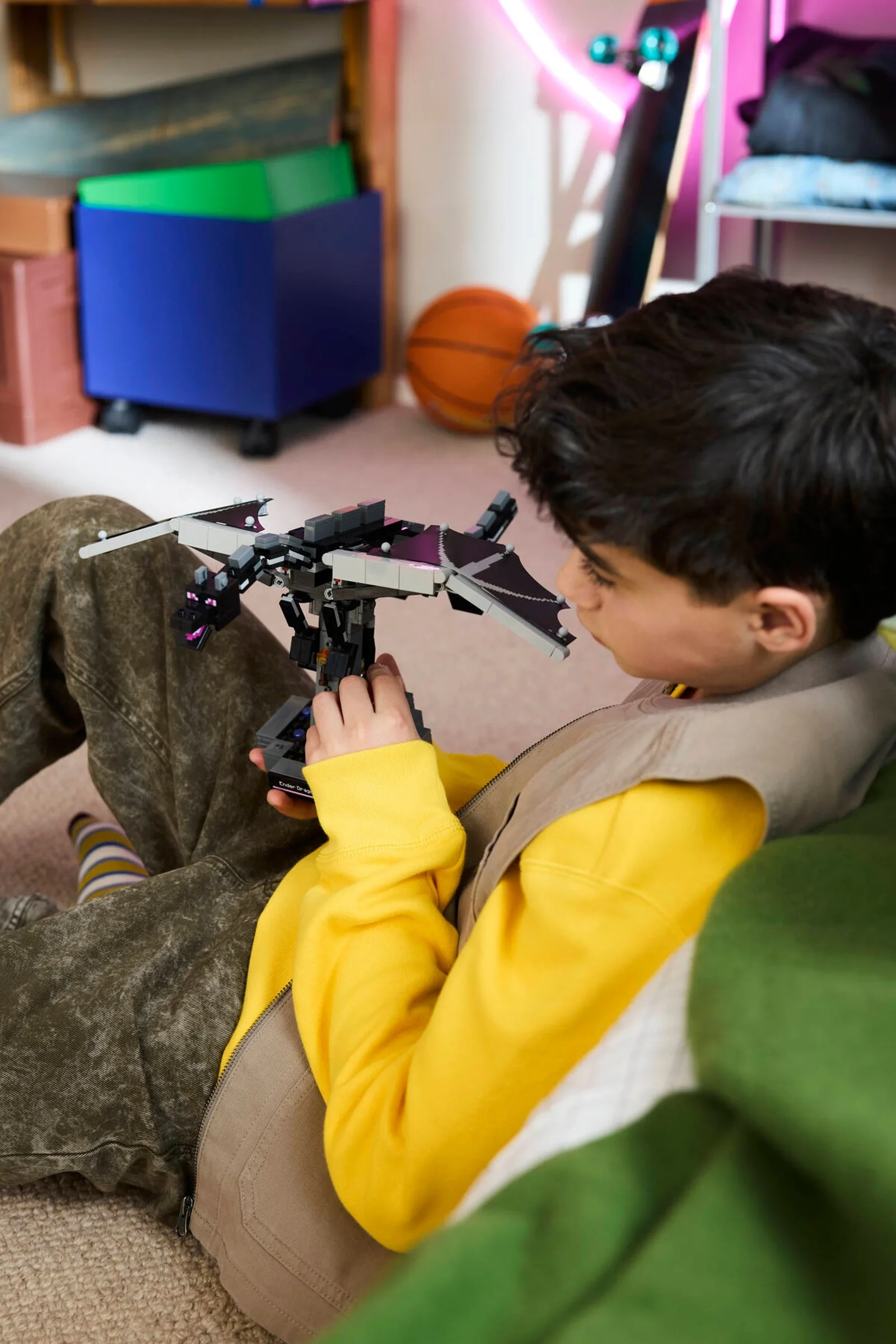 Băiat se joacă cu Ender Dragonul LEGO Minecraft, concentrat și entuziasmat.