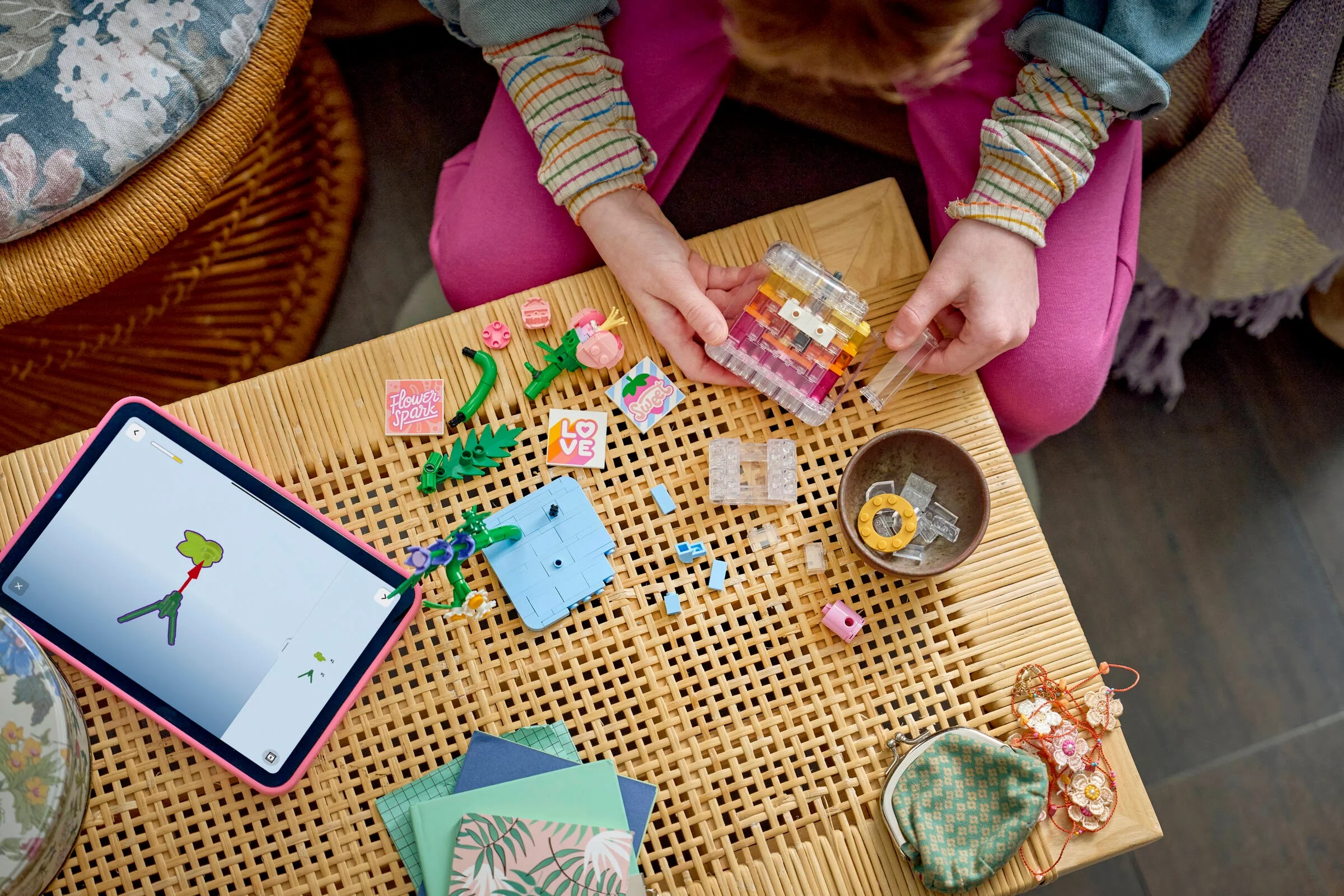 O fetiță construiește setul LEGO 31383, urmând instrucțiunile de pe tabletă.