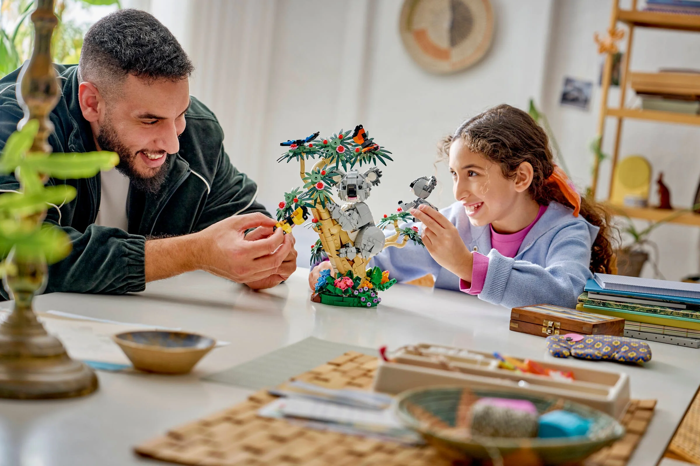 Construiește familia de koala LEGO® Creator 3-în-1. Un tată și o fiică se joacă cu setul.