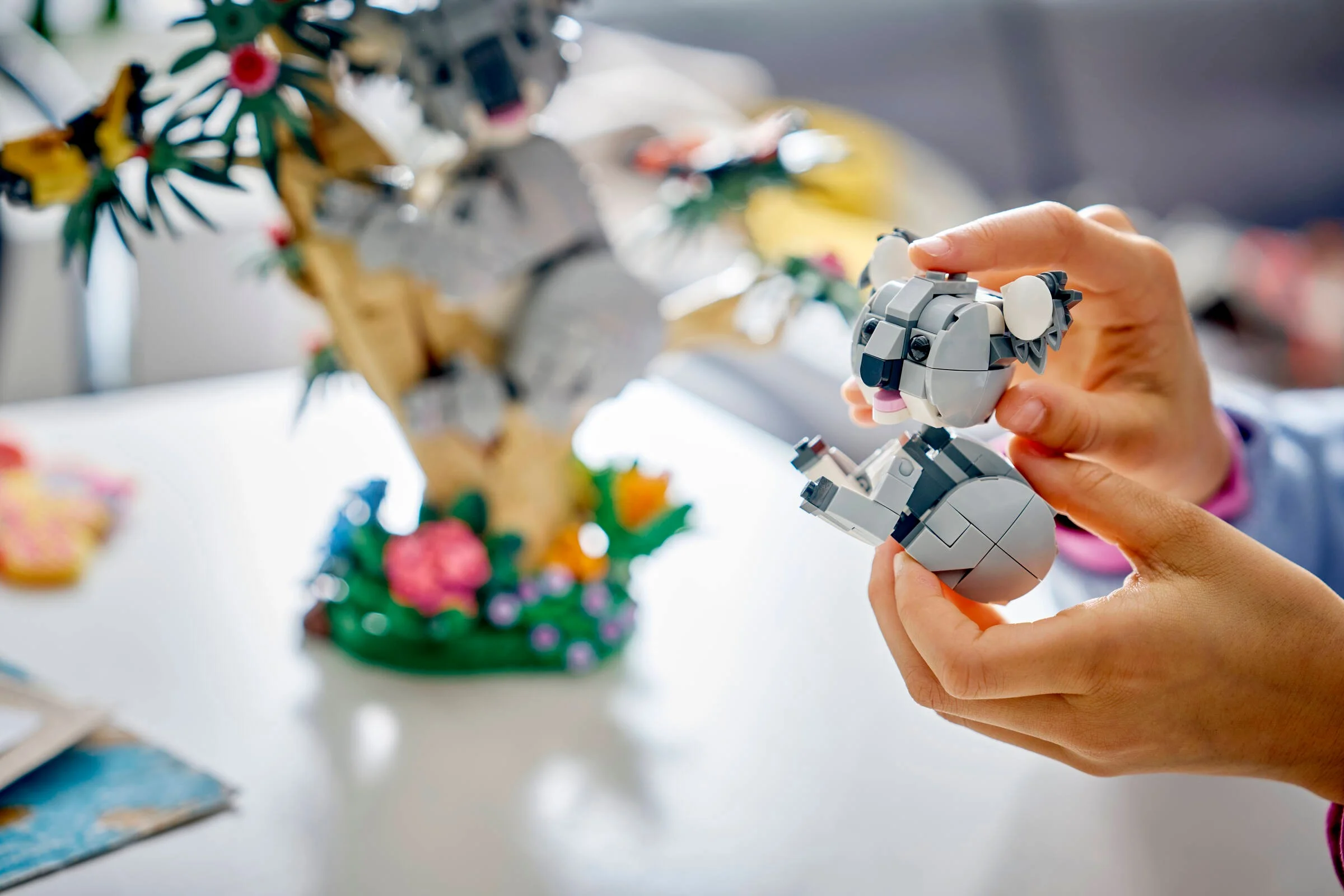 Copil ține un pui de koala LEGO în mână, parte din setul 31388.
