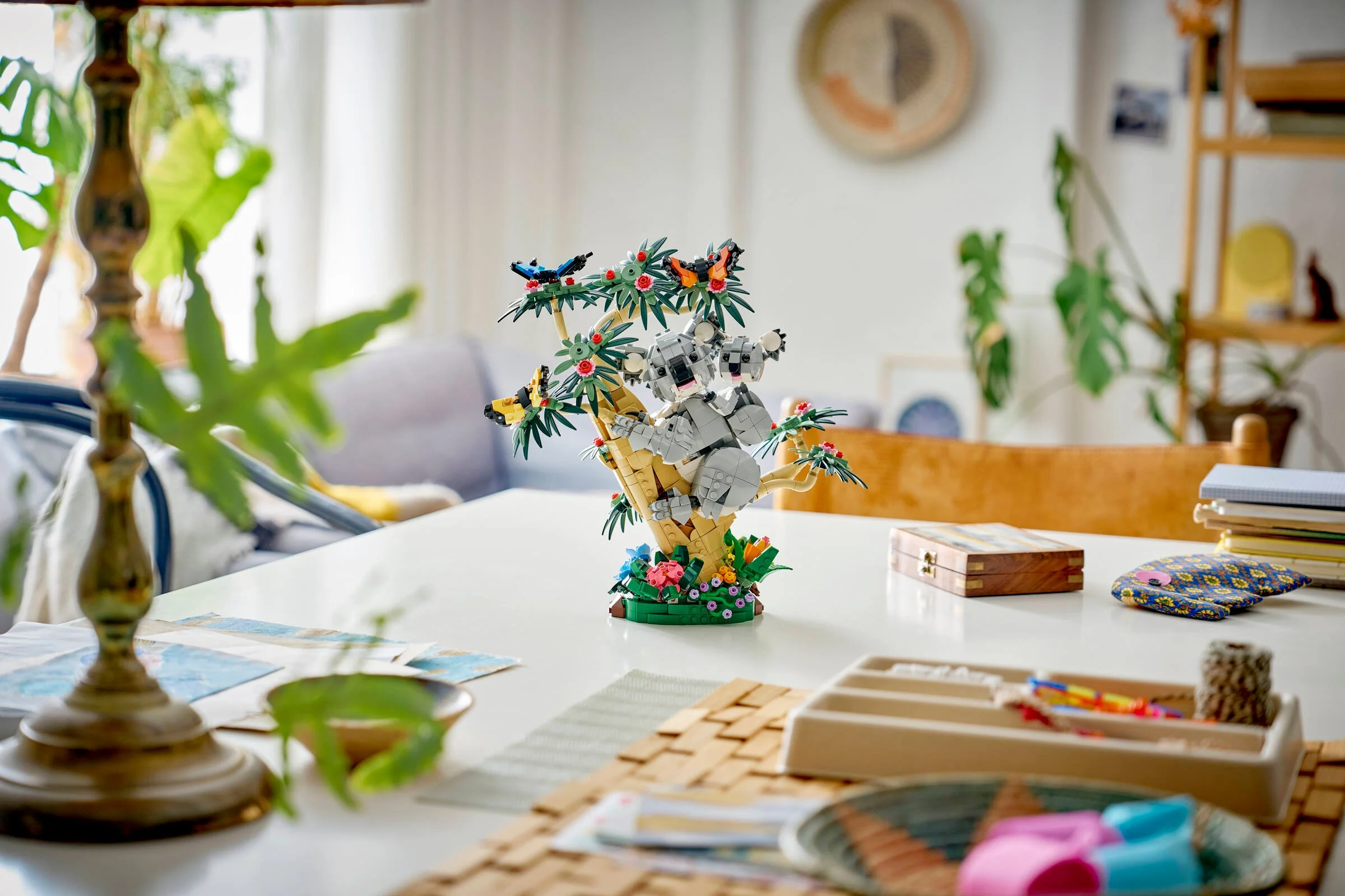 Imagine cu familia de koala LEGO Creator, aranjată pe o masă într-un decor casnic modern.