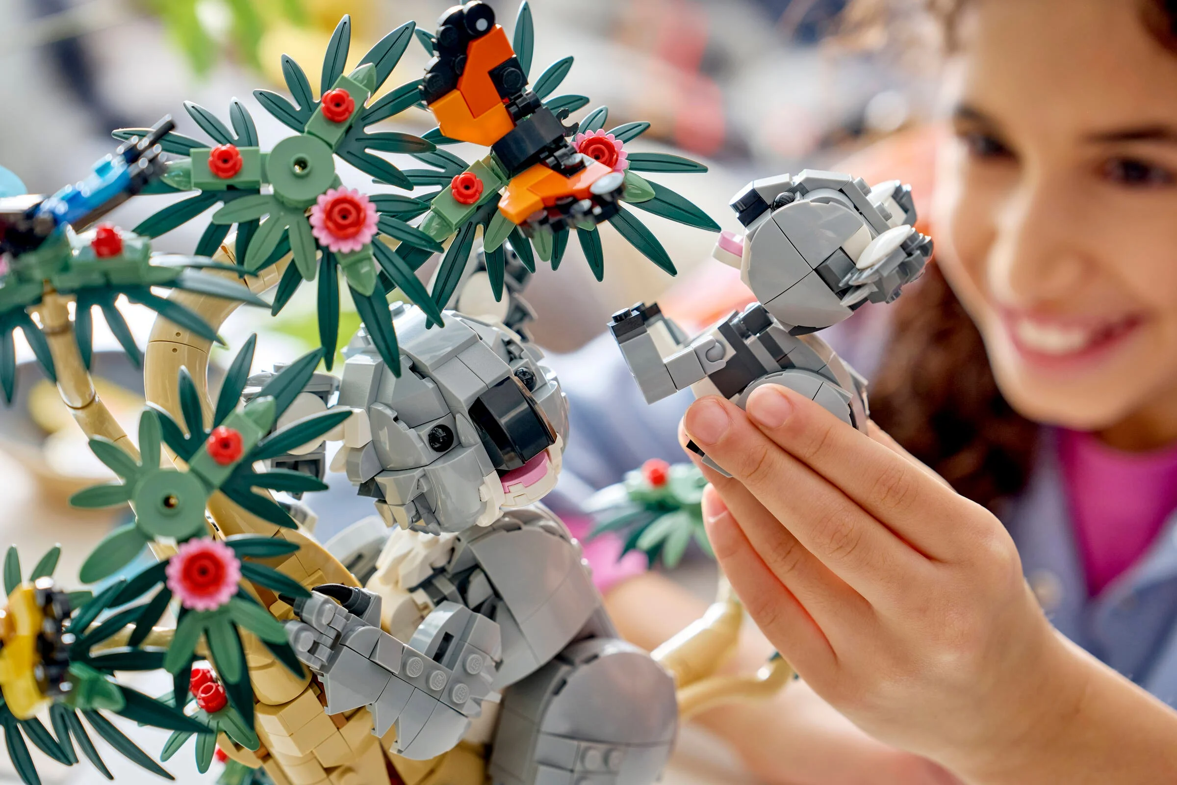 O fetiță se joacă cu setul LEGO Koala, explorând creativitatea.