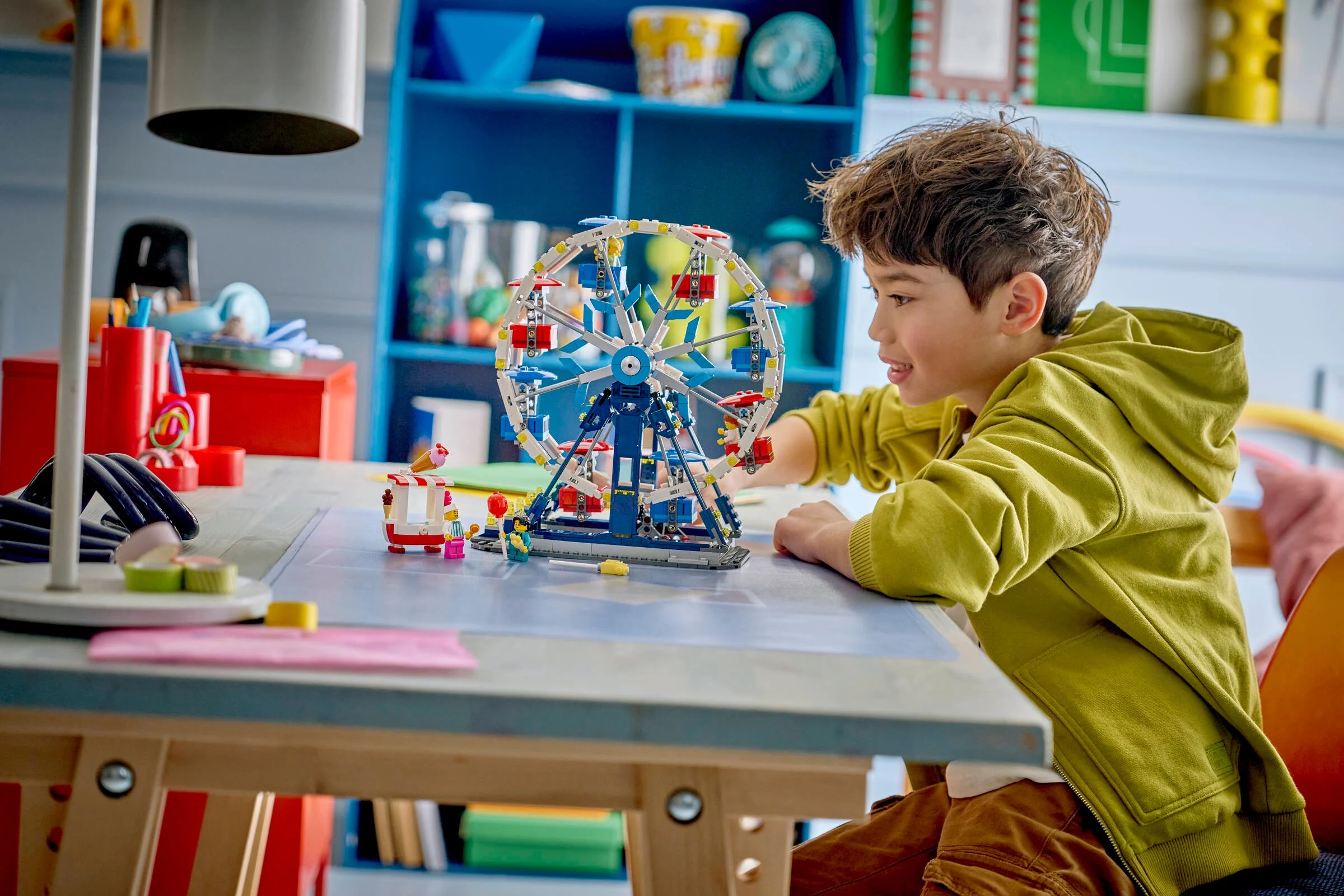 Copil zâmbind construind roata iconică LEGO 31389. Distracție și creativitate!