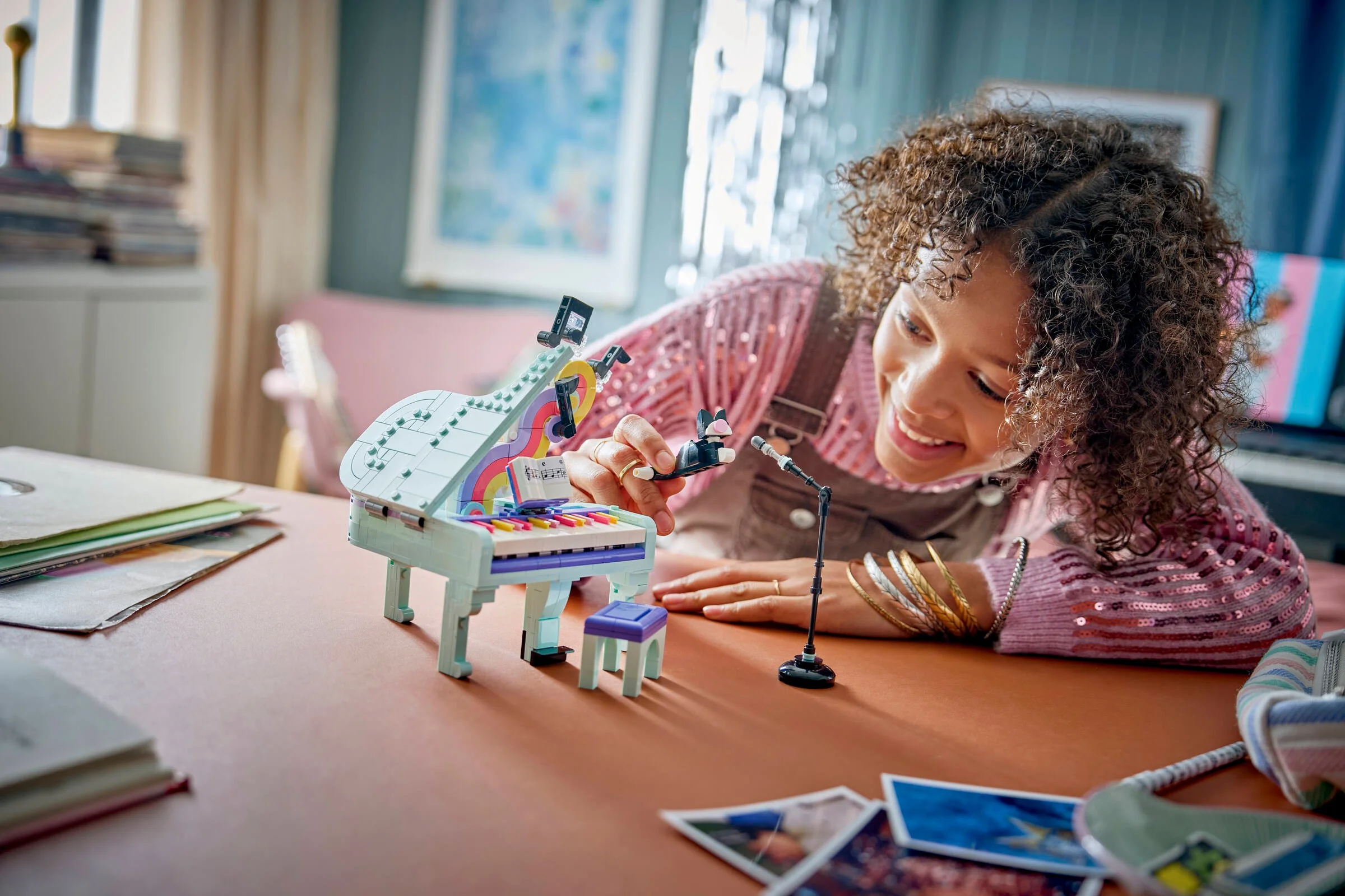 Fată zâmbitoare interacționând cu pianul LEGO, arătând dimensiunea și aspectul modelului.