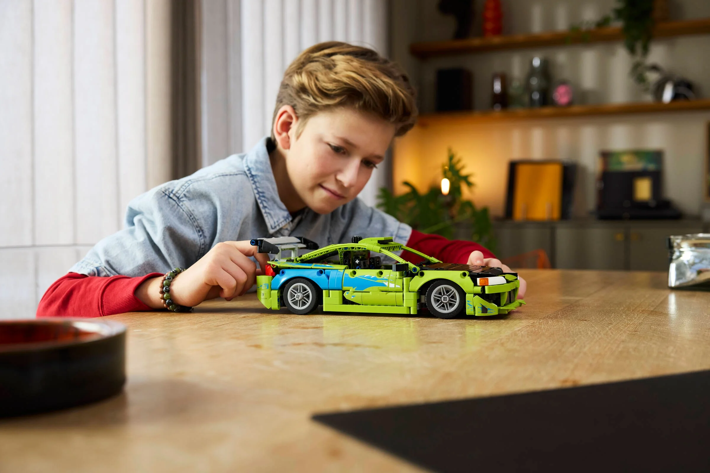 Copil admirând modelul finalizat al Mitsubishi Eclipse, verde și albastru.