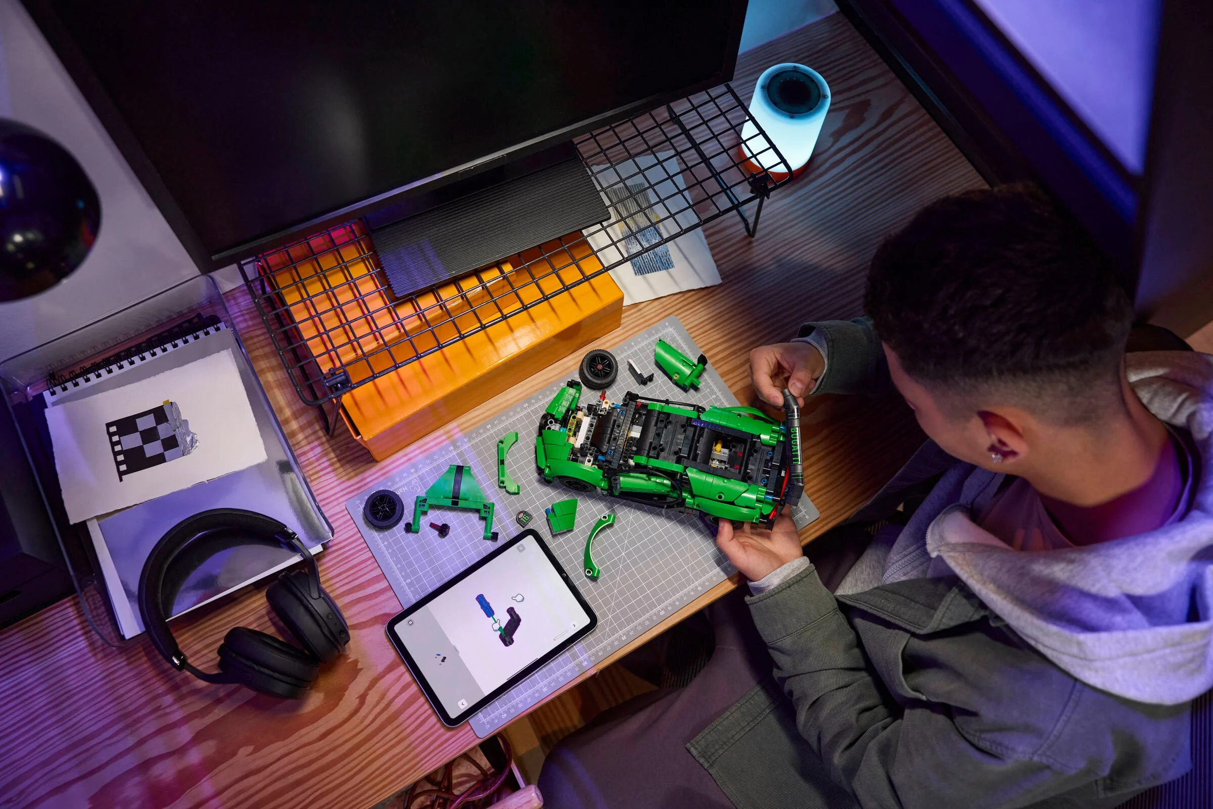 Persoană construind modelul Bugatti Chiron Pur Sport (42241) cu instrucțiuni digitale pe tabletă.