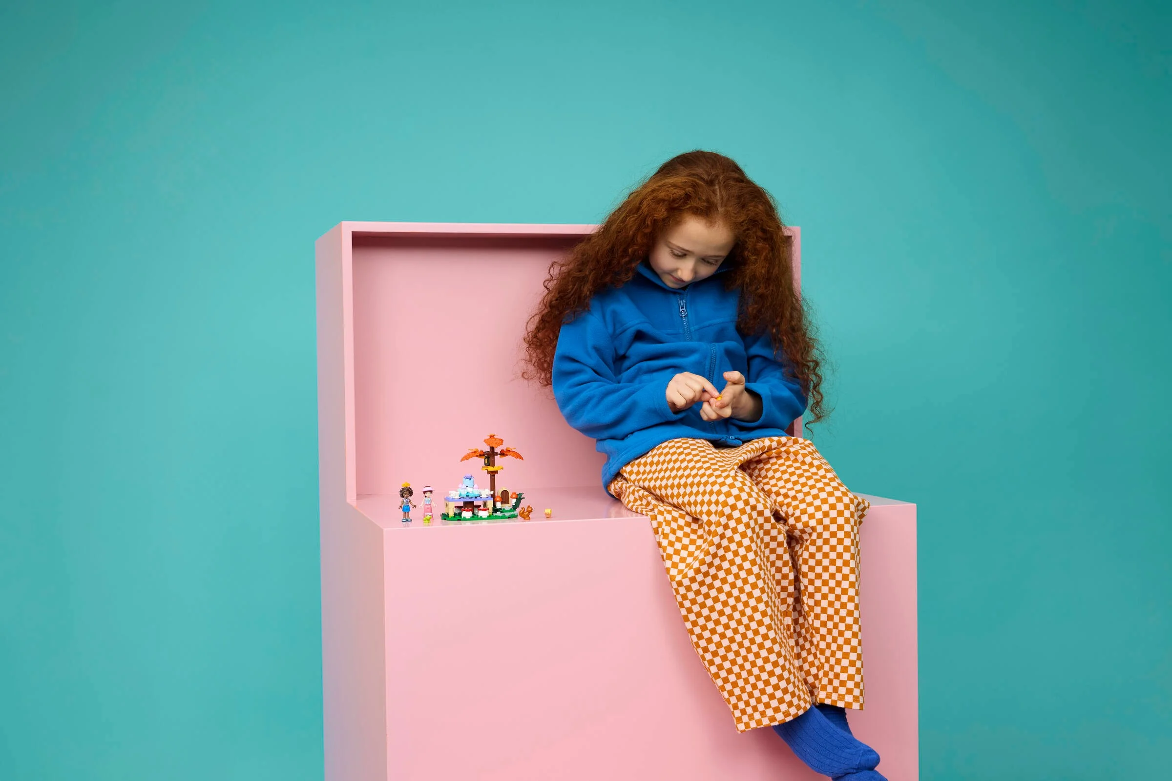 O fetiță se joacă cu setul LEGO Friends 42690, într-o scenă colorată și jucăușă.