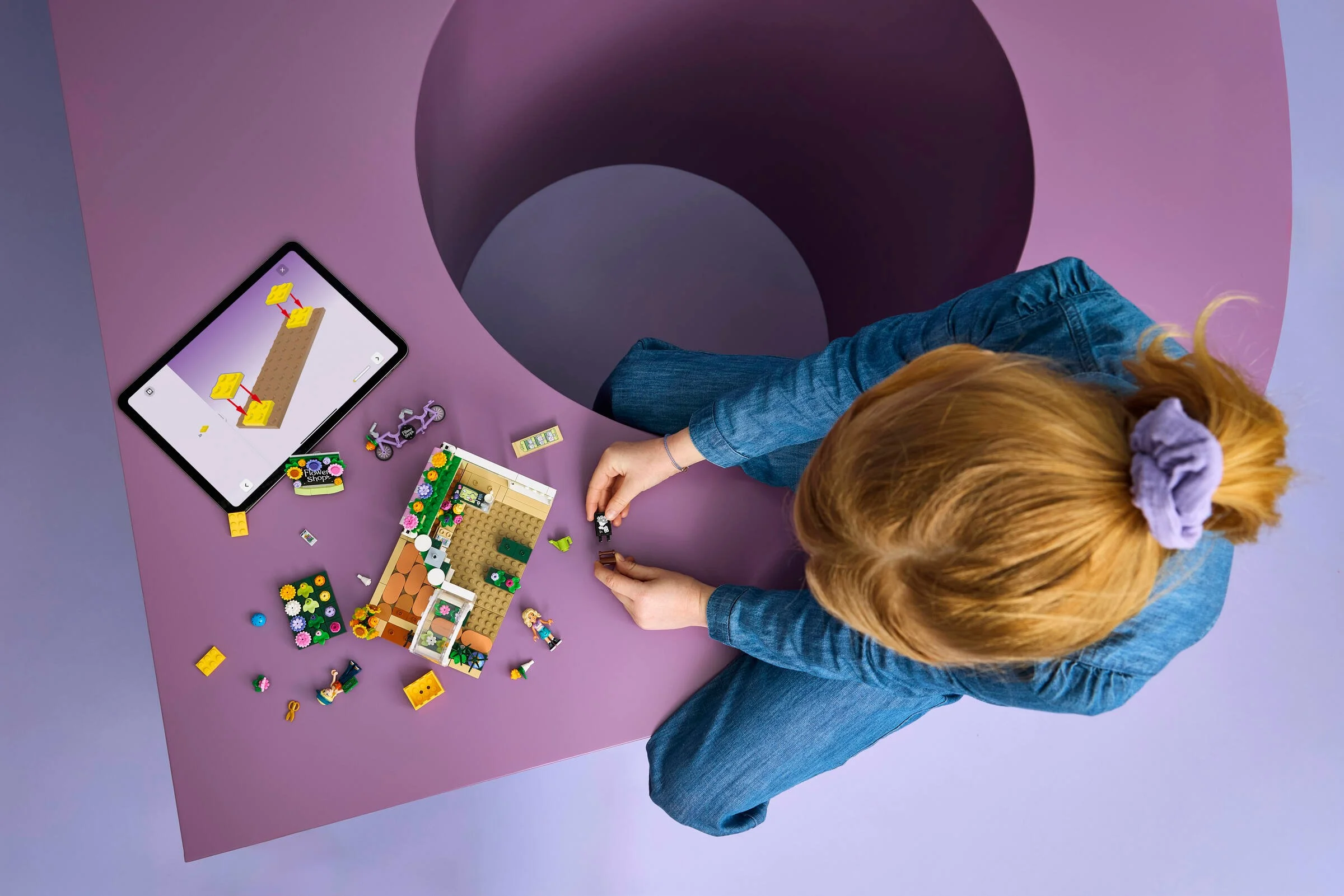 Persoană construind setul LEGO Friends 42693, magazin de flori creativ.
