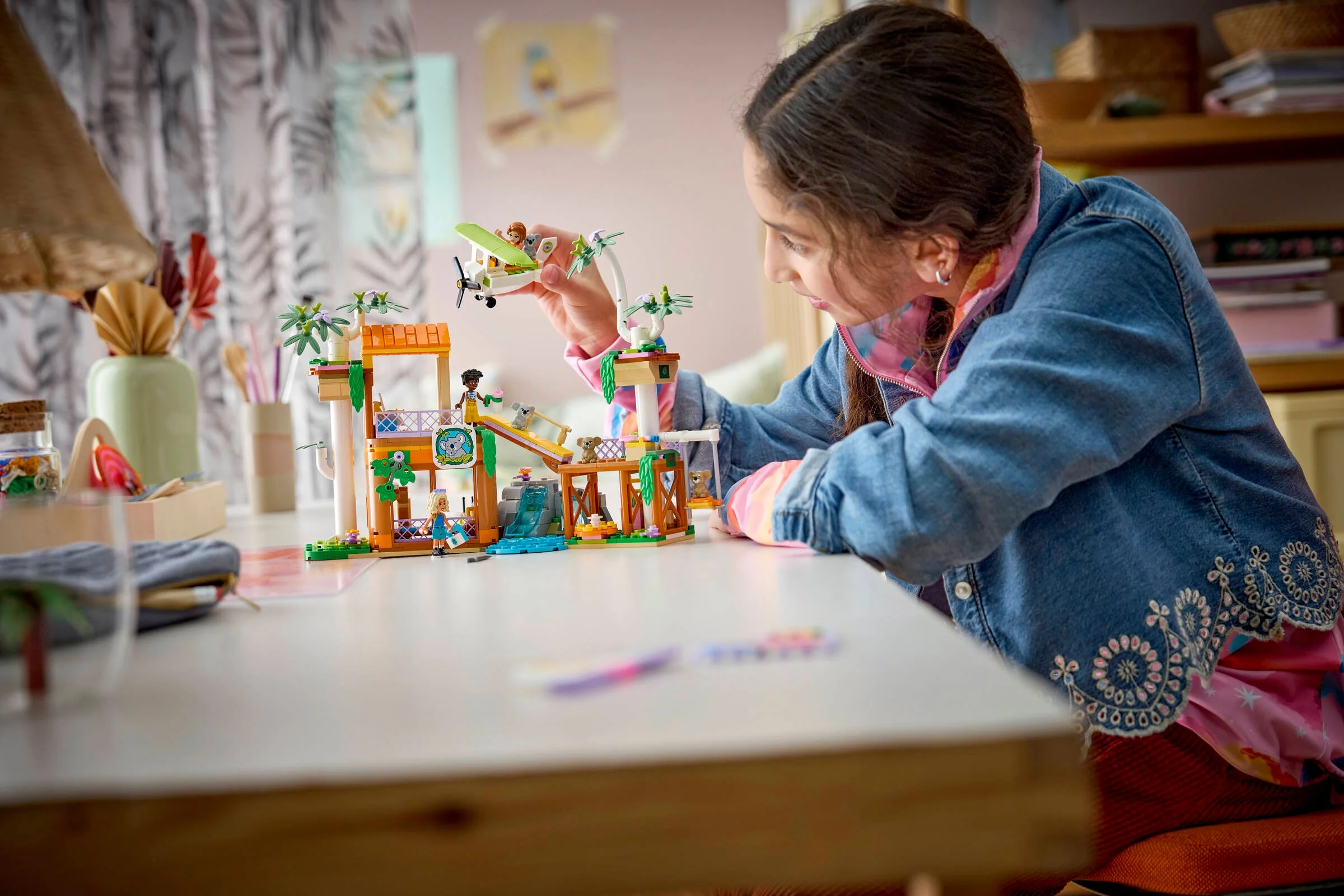 O fetiță se joacă cu setul LEGO 42701 Centrul de Îngrijire a Koalelor.