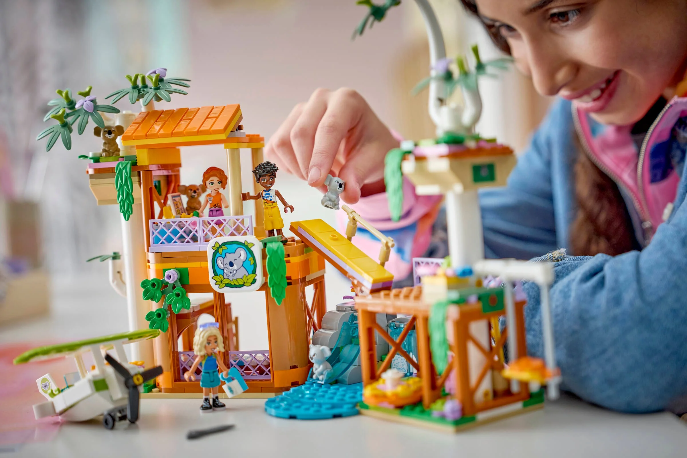 Imagine cu setul LEGO 42701, habitatul koala și centrul de îngrijire, o fată jucându-se cu el.