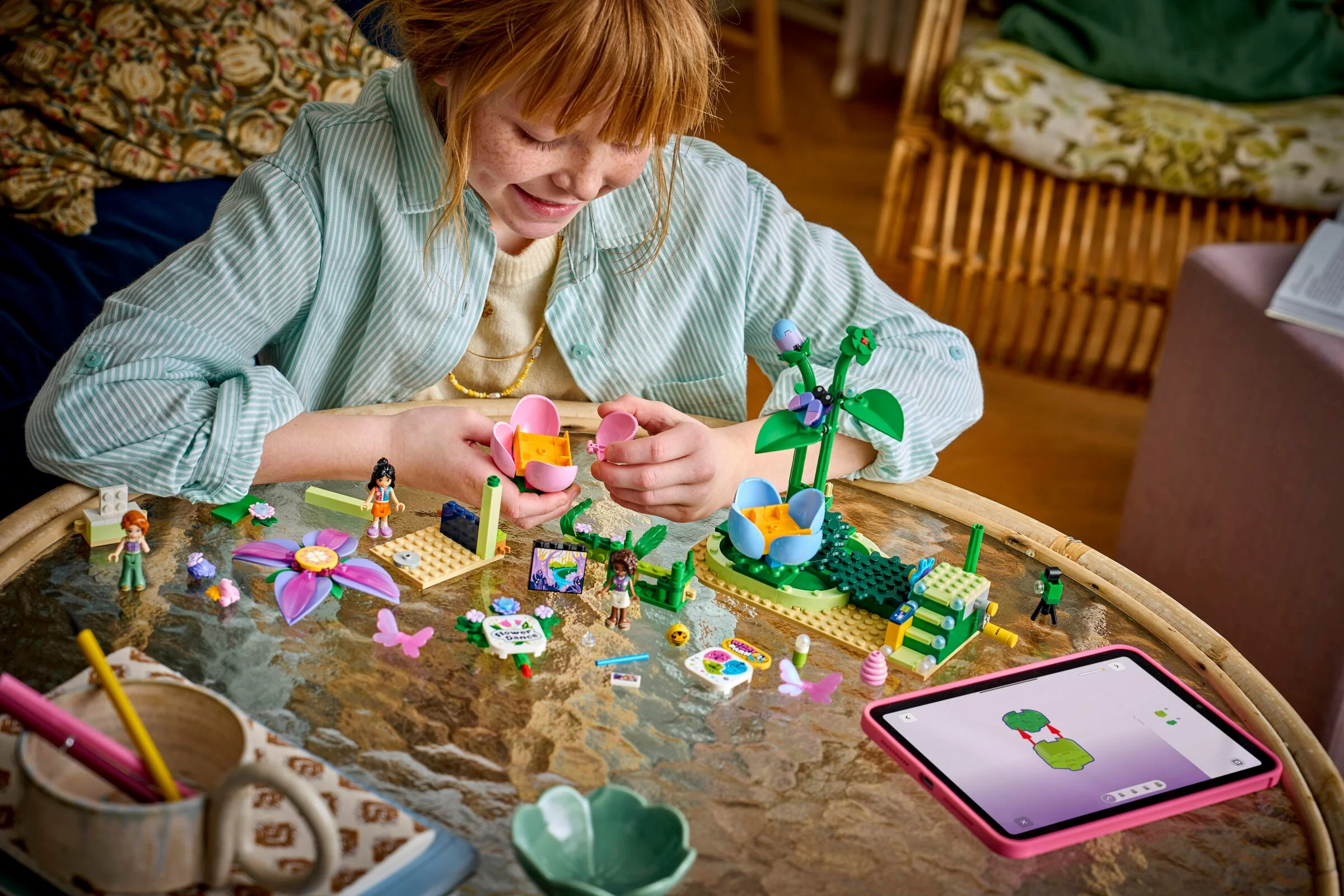 Fată construind setul LEGO Friends cu o floare rotitoare și o ceașcă de ceai. Pare distractiv!