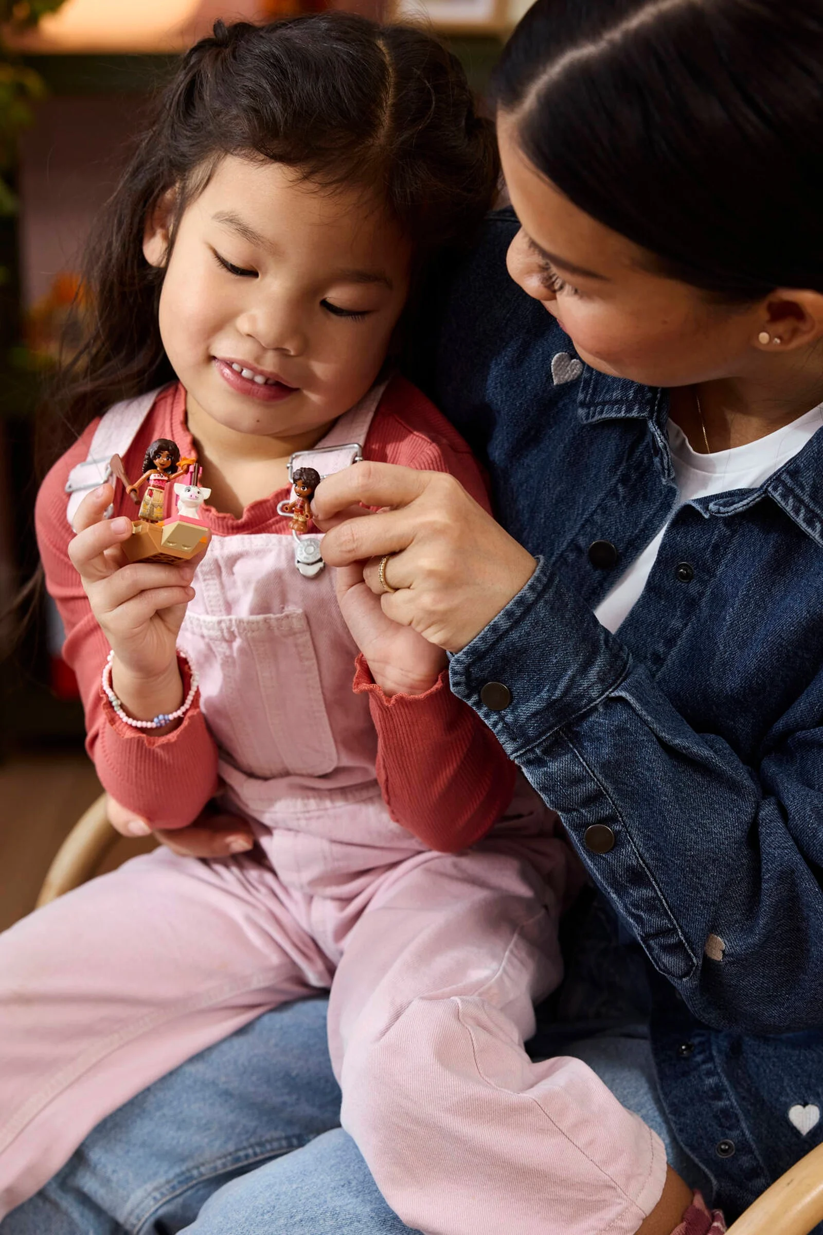 Fetiță și femeie admiră mini-figurinele Moana LEGO. Interacțiune mamă-fiică cu jucăria.