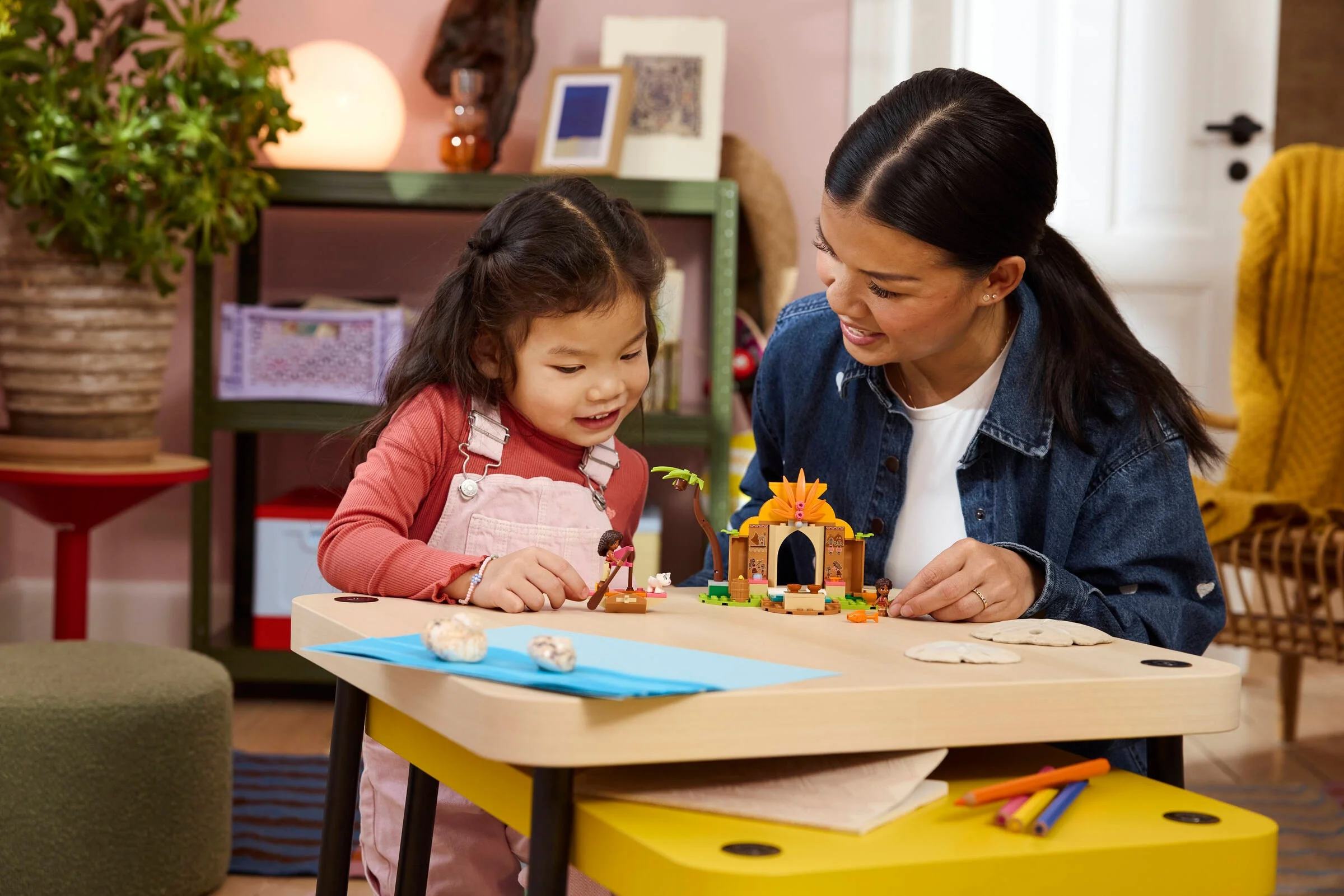 O fetiță și o femeie construiesc împreună setul LEGO 43282, într-o scenă caldă și familială.