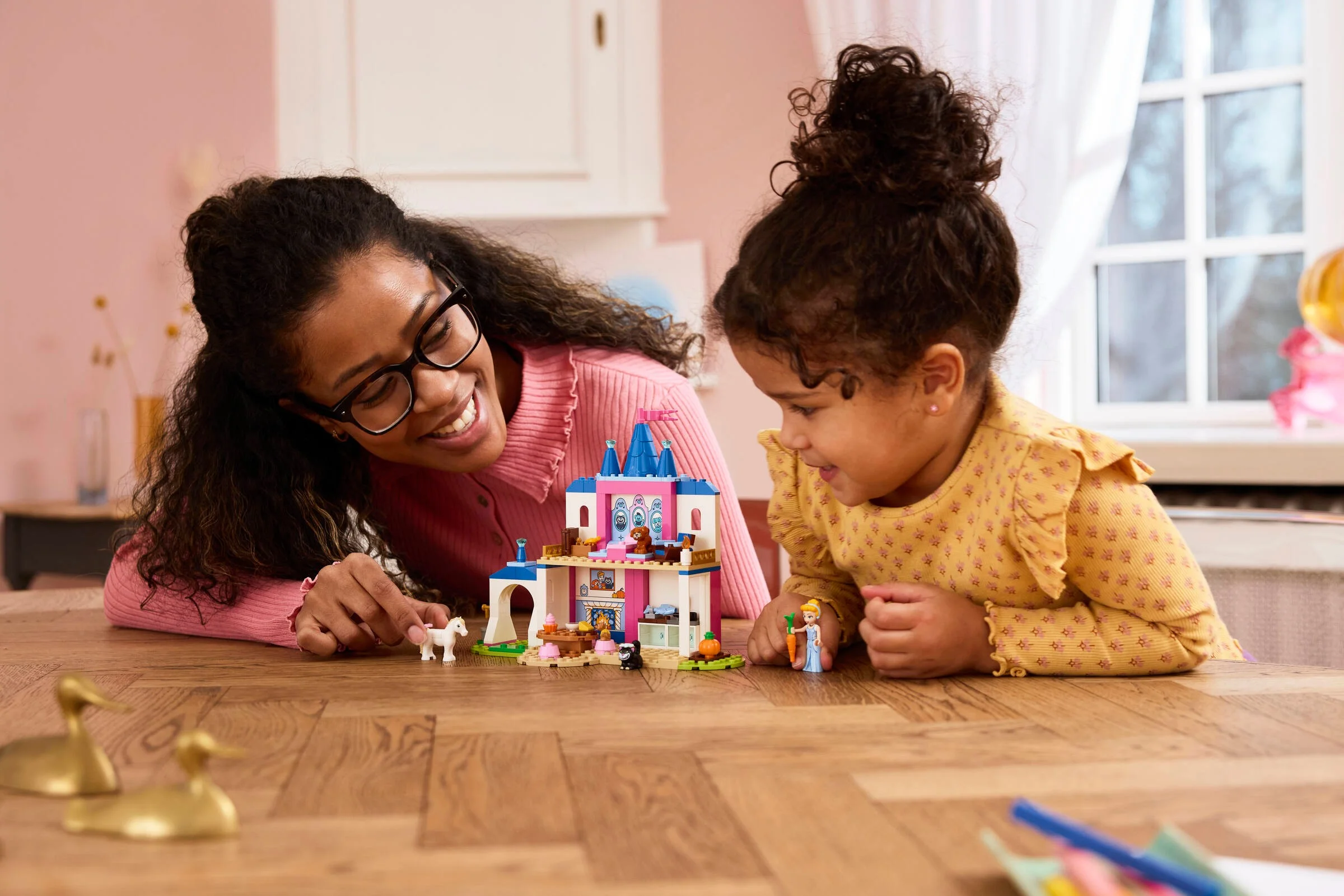 Mamă și fiică construind împreună castelul LEGO Cinderella. Bucurie și joacă în familie!