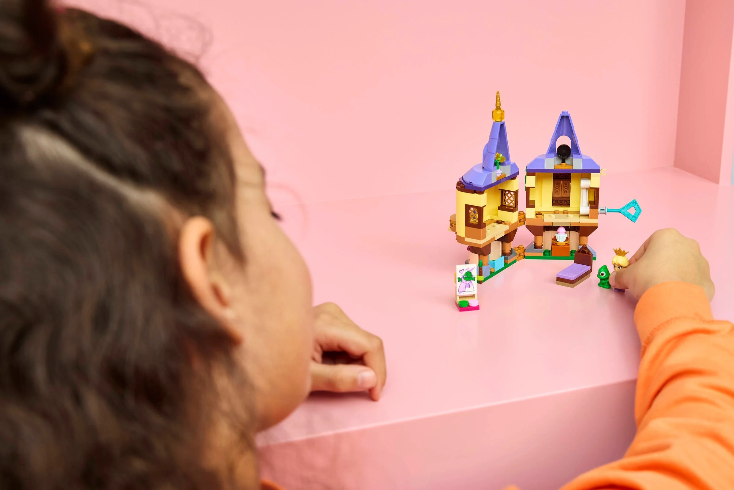Copil se joacă cu setul LEGO Turnul Mini al lui Rapunzel. O experiență magică și distractivă.