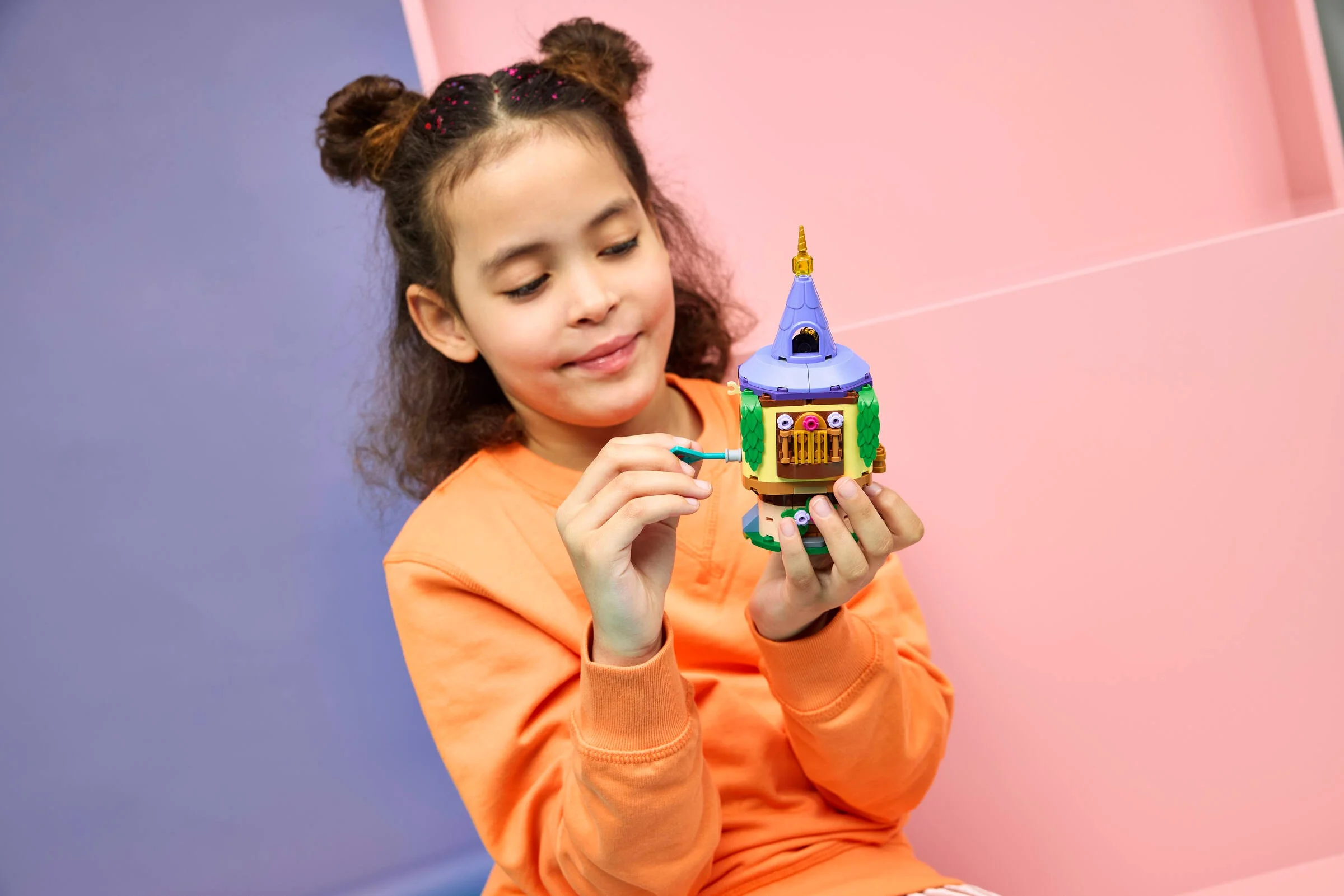 Fată interacționând cu turnul LEGO Rapunzel, evidențiind funcțiile și detaliile acestuia.