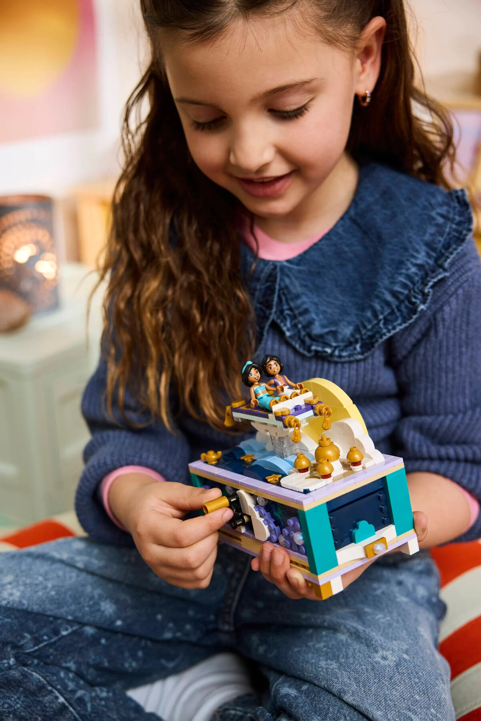 Fetiță interacționând cu setul LEGO 43295, Cutia de bijuterii a lui Jasmine. Prim-plan, zâmbet, joacă.