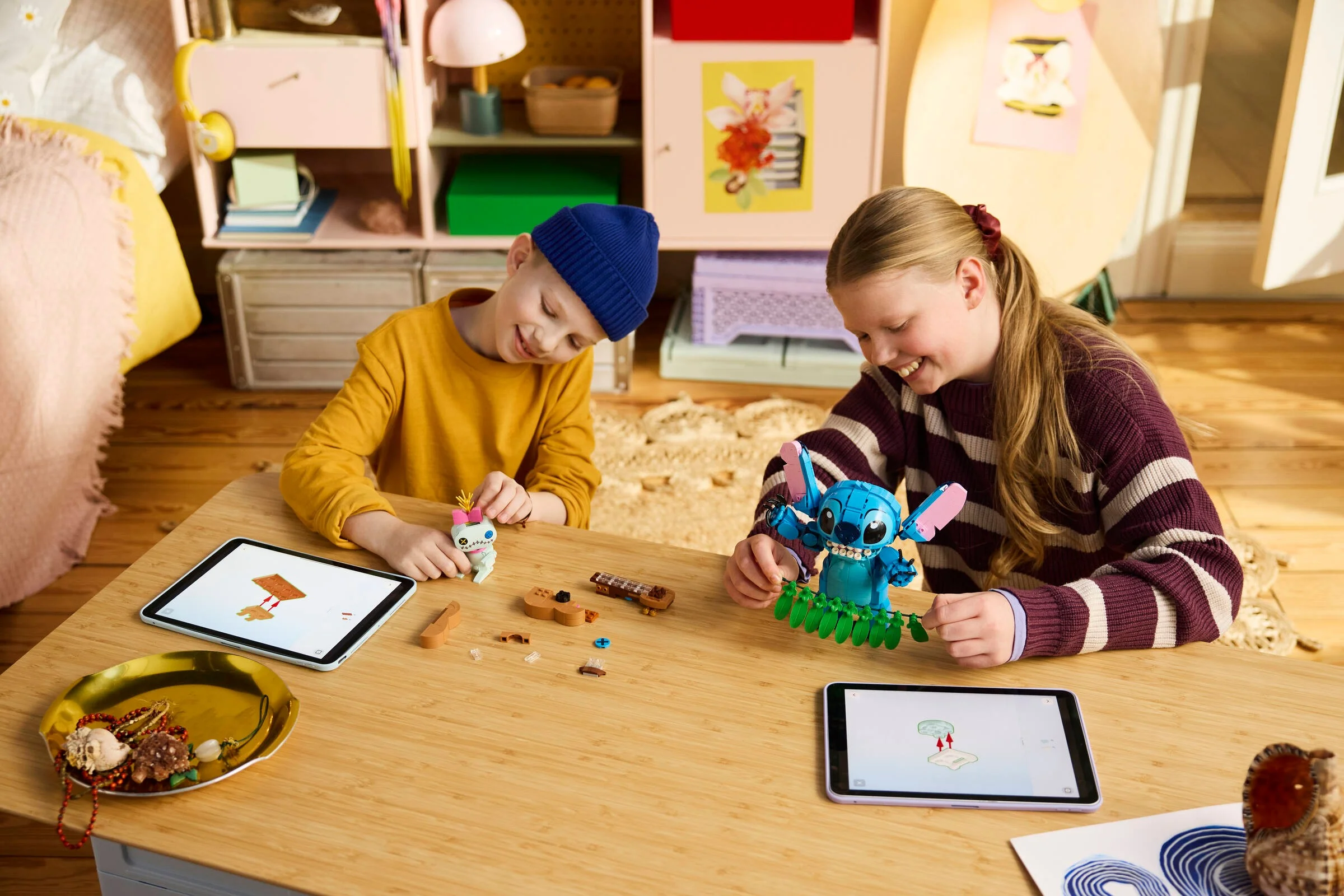 Copii construind setul LEGO Stitch și Scrump, urmărind instrucțiunile pe tabletă.