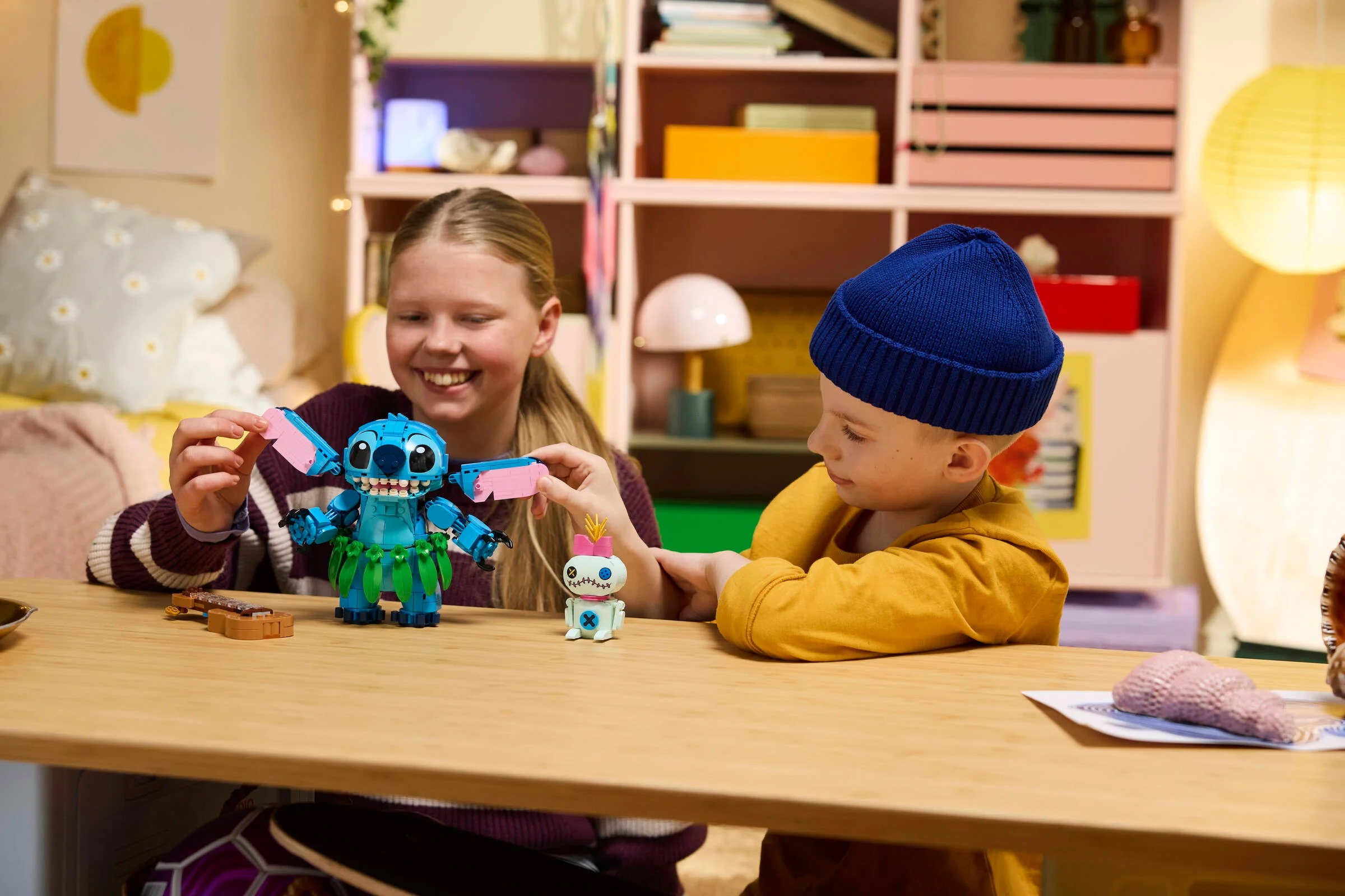 Copii se joacă cu setul LEGO Stitch și Scrump, zâmbete și distracție garantată.