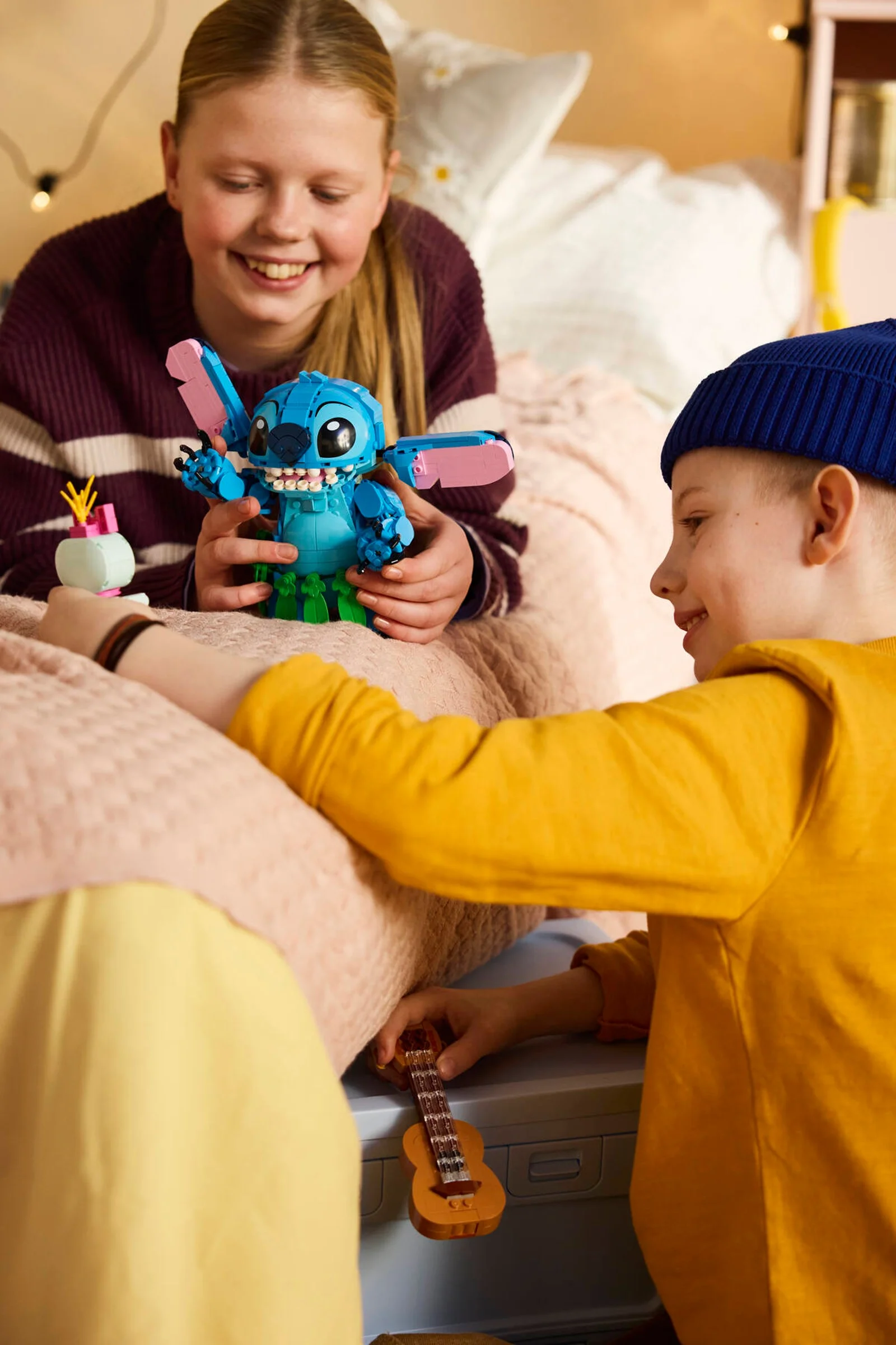 Copii se joacă cu Stitch și Scrump construite din LEGO. Atmosferă relaxată, de joacă.
