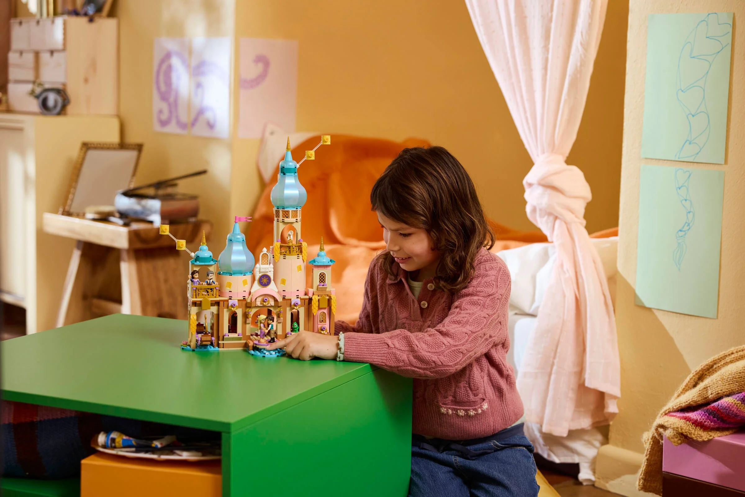 O fetiță se joacă cu castelul LEGO Rapunzel, explorând detaliile și minifigurinele incluse.