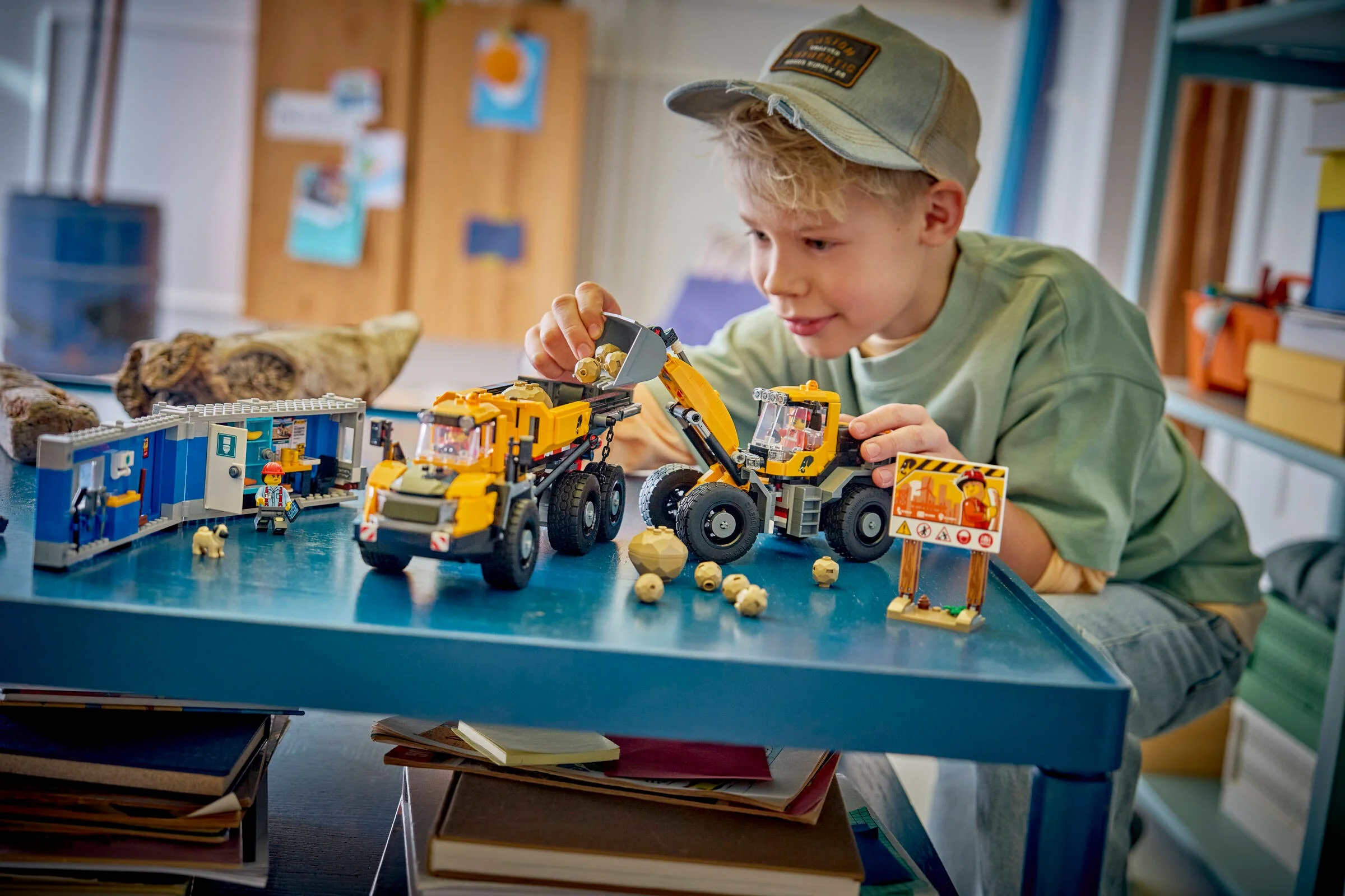 Un băiat se joacă cu setul LEGO 60494, încărcând pietre în camion cu încărcătorul frontal.