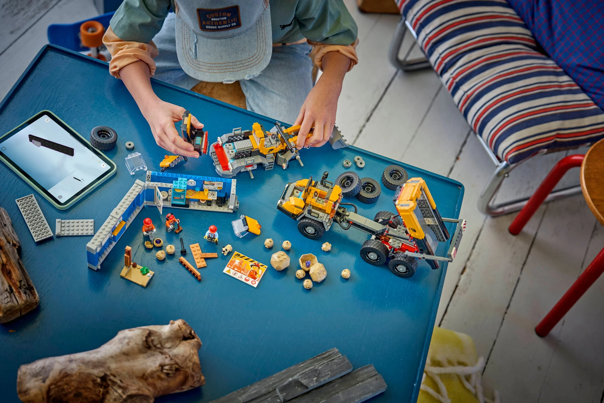 Copil construind setul LEGO 60494, cu camioane și accesorii. Construcție distractivă! 