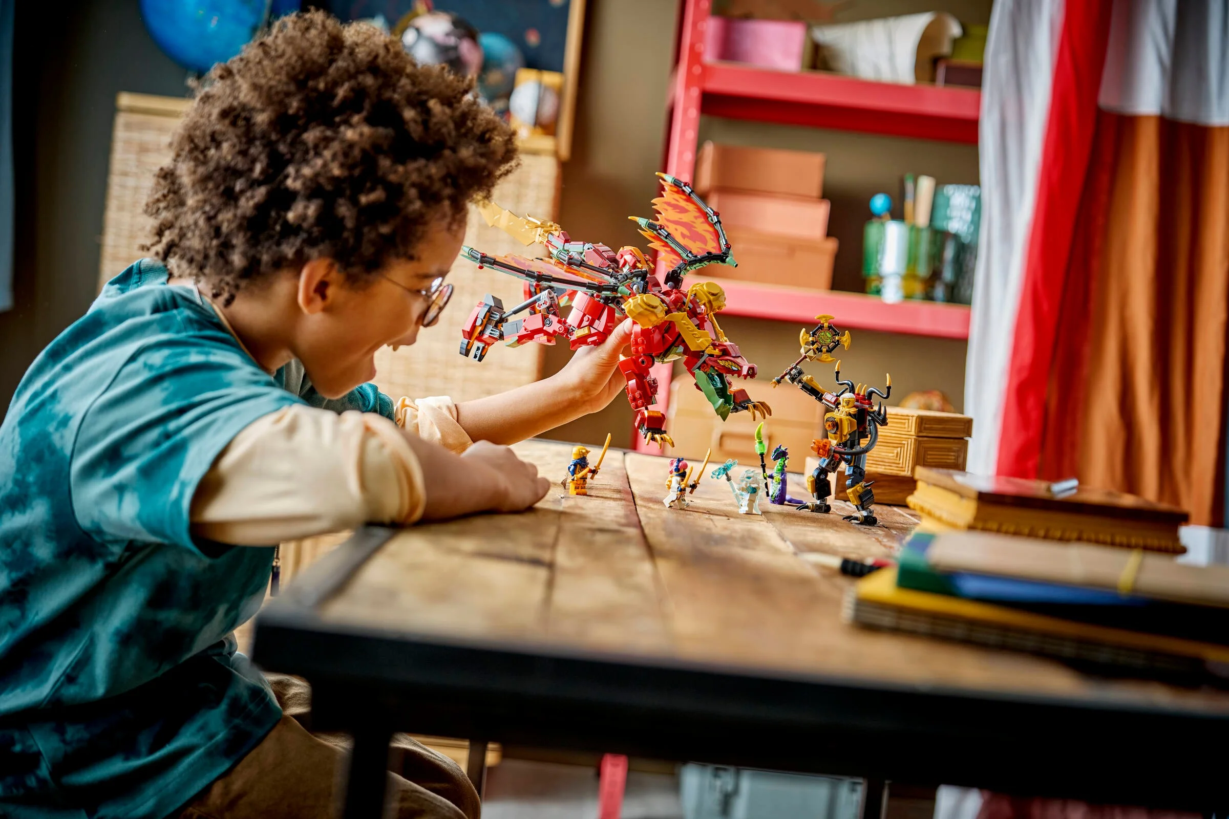 Un copil se joacă cu setul LEGO Ninjago, mech dragon transformabil Wyldfyre (71868).