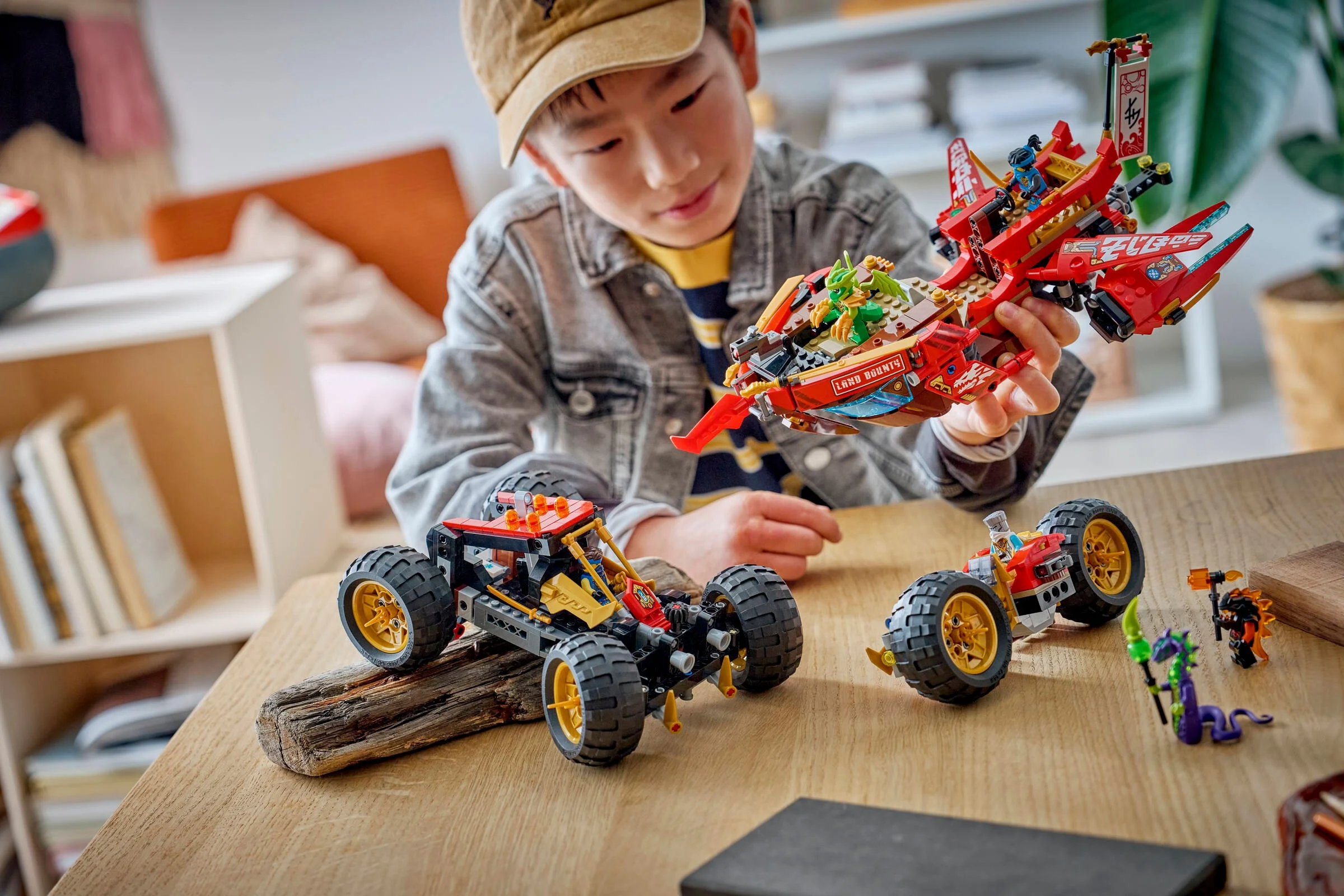 Un băiat se joacă cu setul LEGO Ninjago Land Bounty. Modelul principal este ținut în mână.