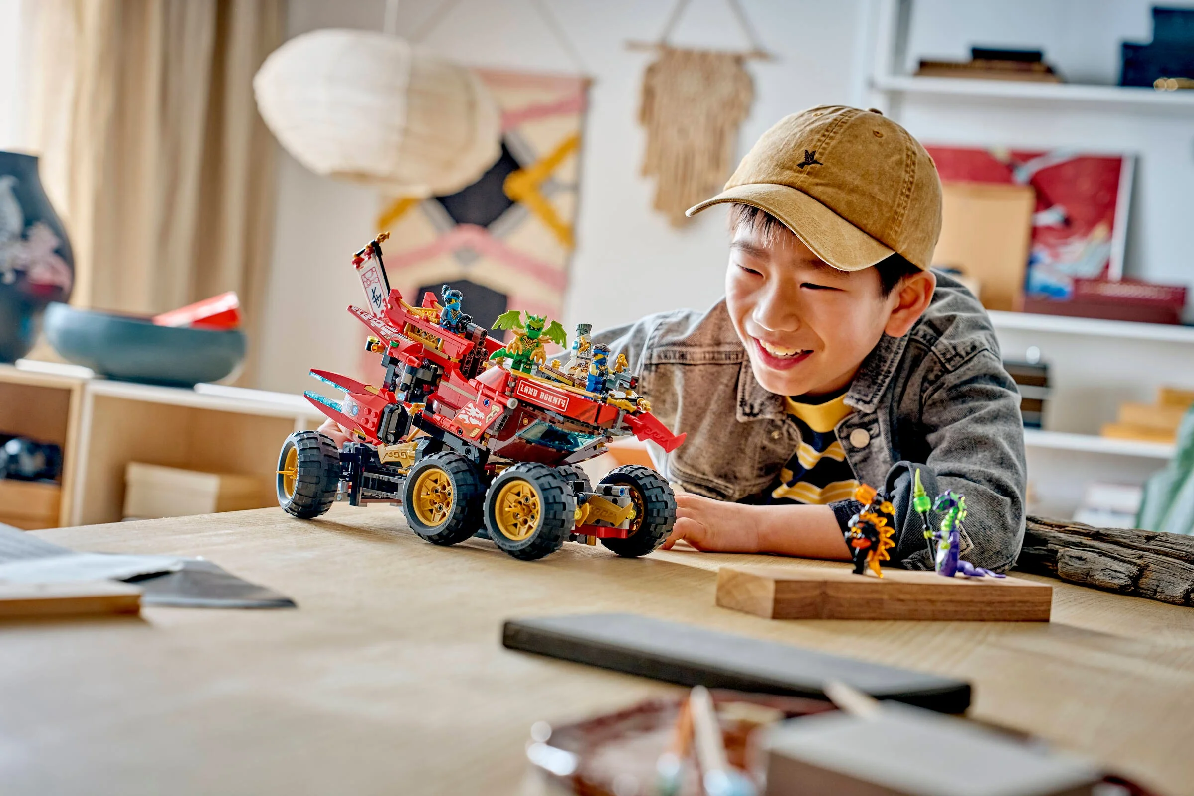 Băiat zâmbitor se joacă cu Land Bounty, setul LEGO Ninjago 71869.