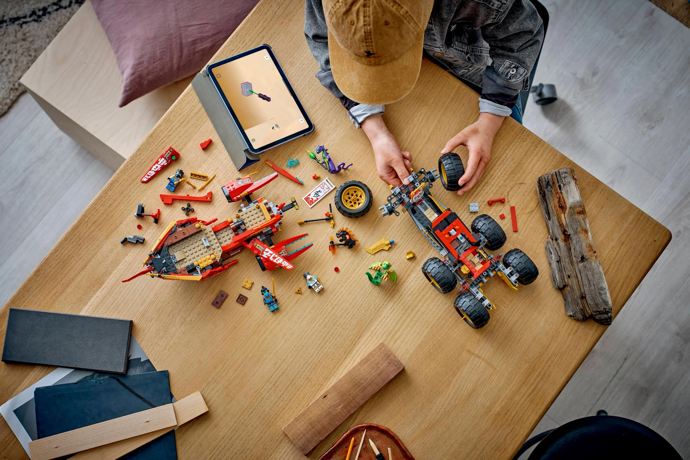 Copil asamblând Land Bounty LEGO, folosind instrucțiuni digitale pe tabletă.