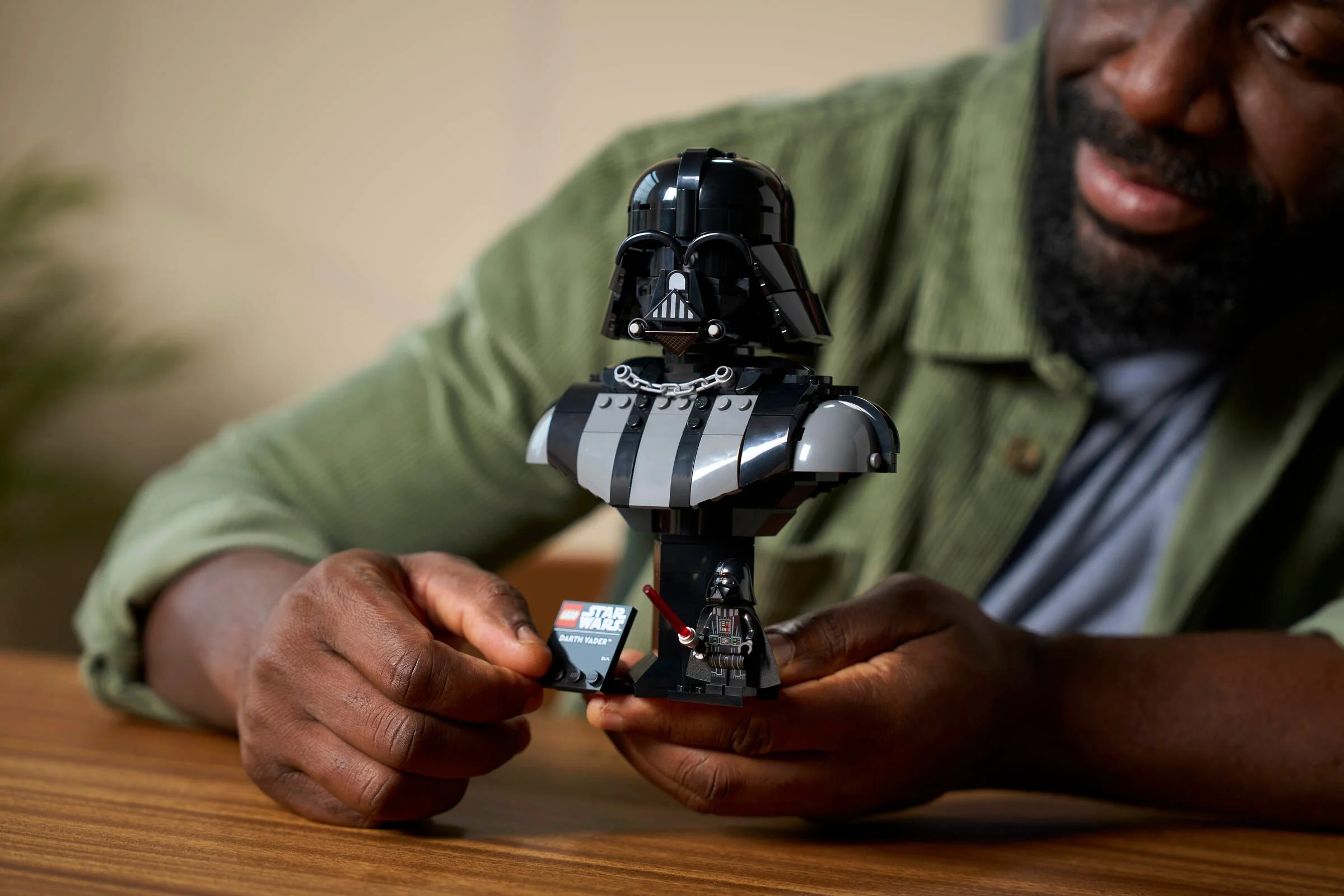 Prim-plan cu bustul Darth Vader LEGO, asamblat de un adult.