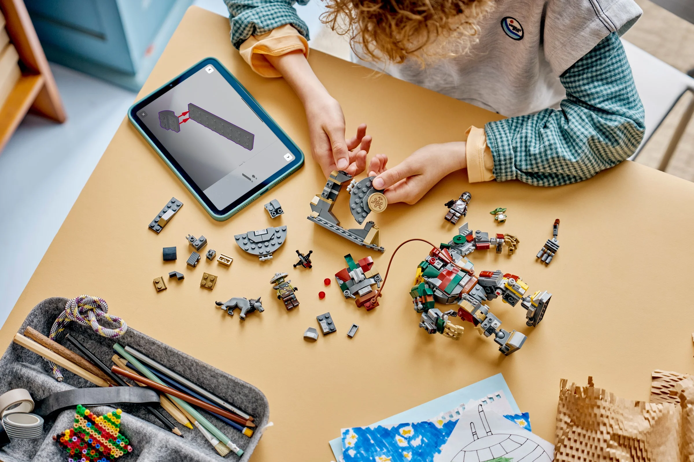 Copil construind robotul LEGO 75451 folosind instrucțiuni digitale pe tabletă.
