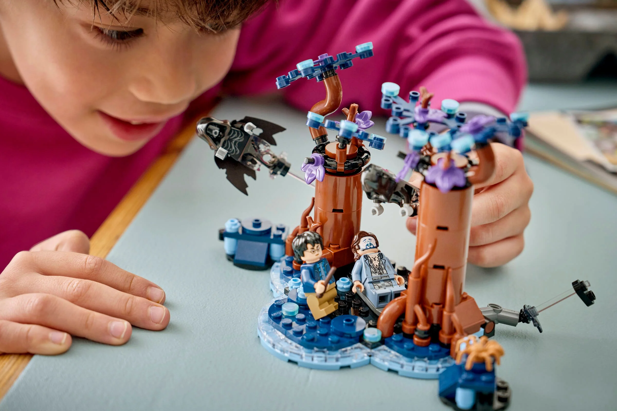 Copil interacționând cu setul LEGO Pădurea Interzisă: Expecto Patronum.