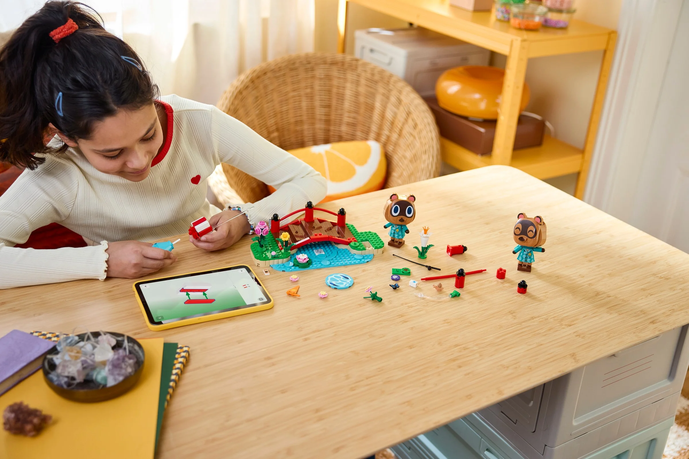 O fată construiește setul LEGO Animal Crossing, folosind instrucțiuni digitale pe o tabletă.