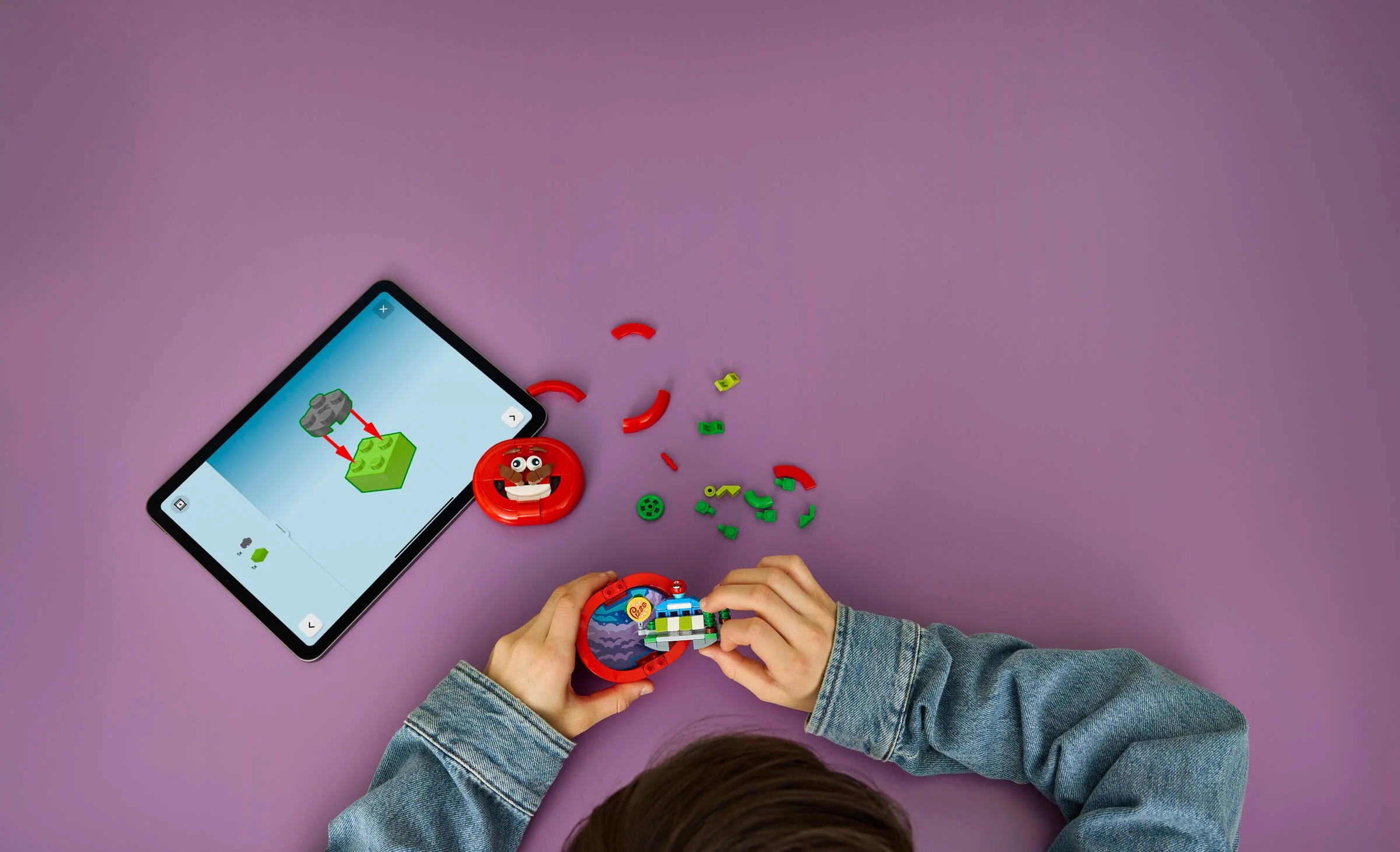 Construirea Tomatohead cu instrucțiuni digitale pe tabletă, pe un fundal mov.