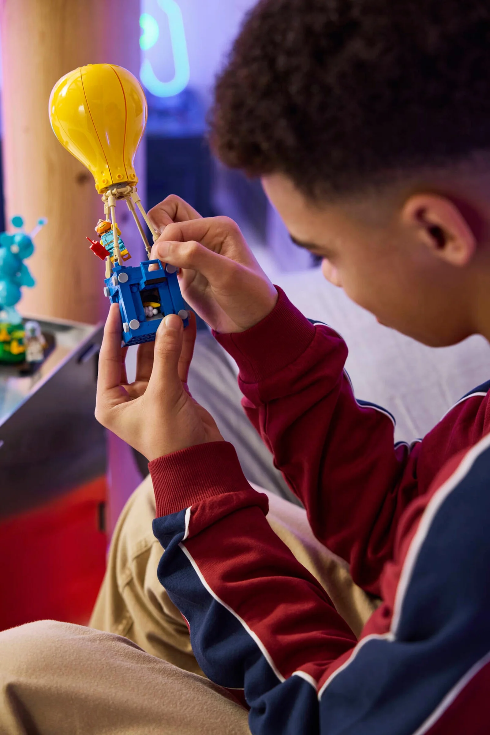 Copil construind setul LEGO Fortnite 77080. Detalii clare și atractive.