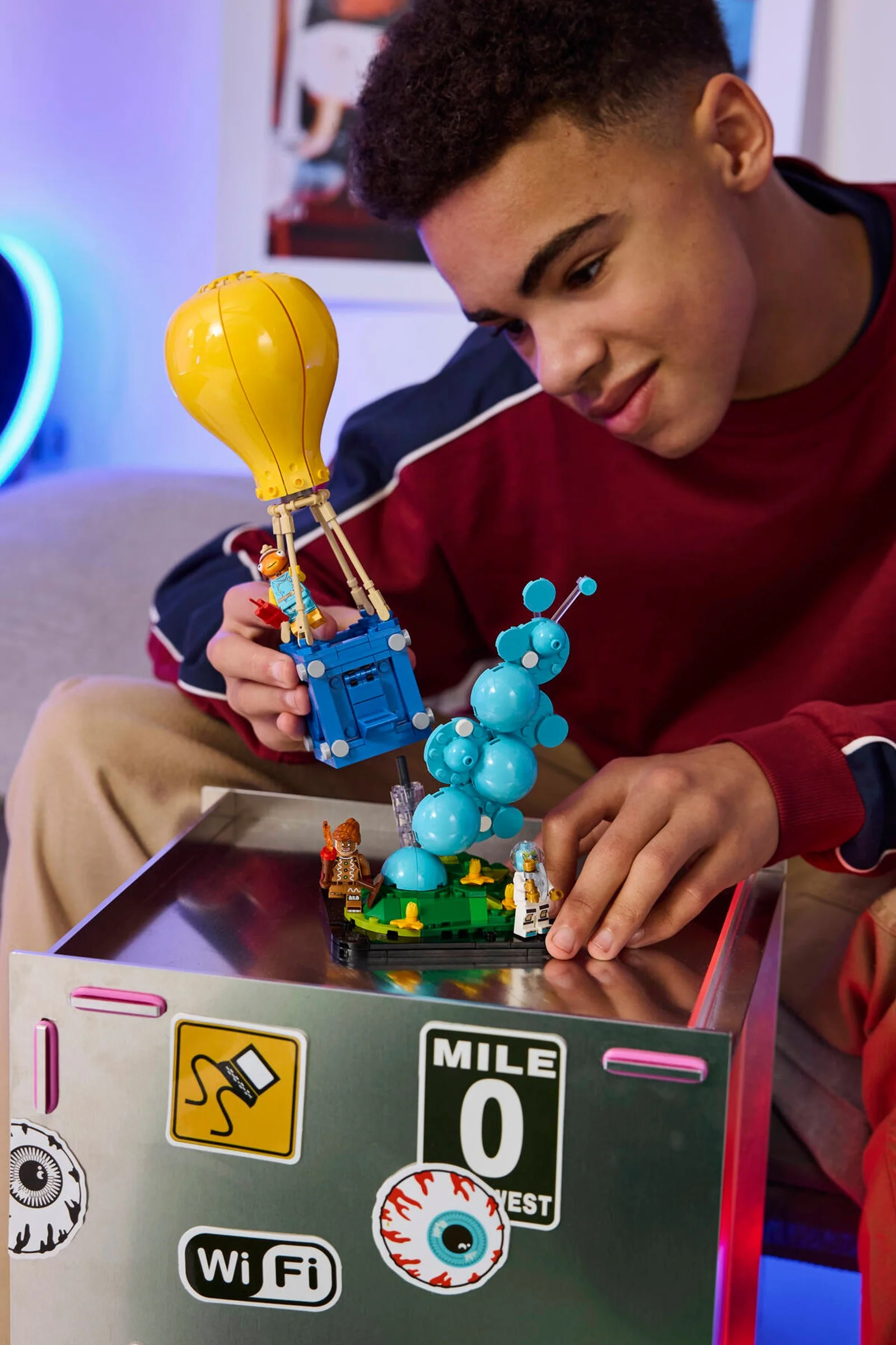 Un tânăr se joacă cu setul LEGO Fortnite Supply Drop (77080).