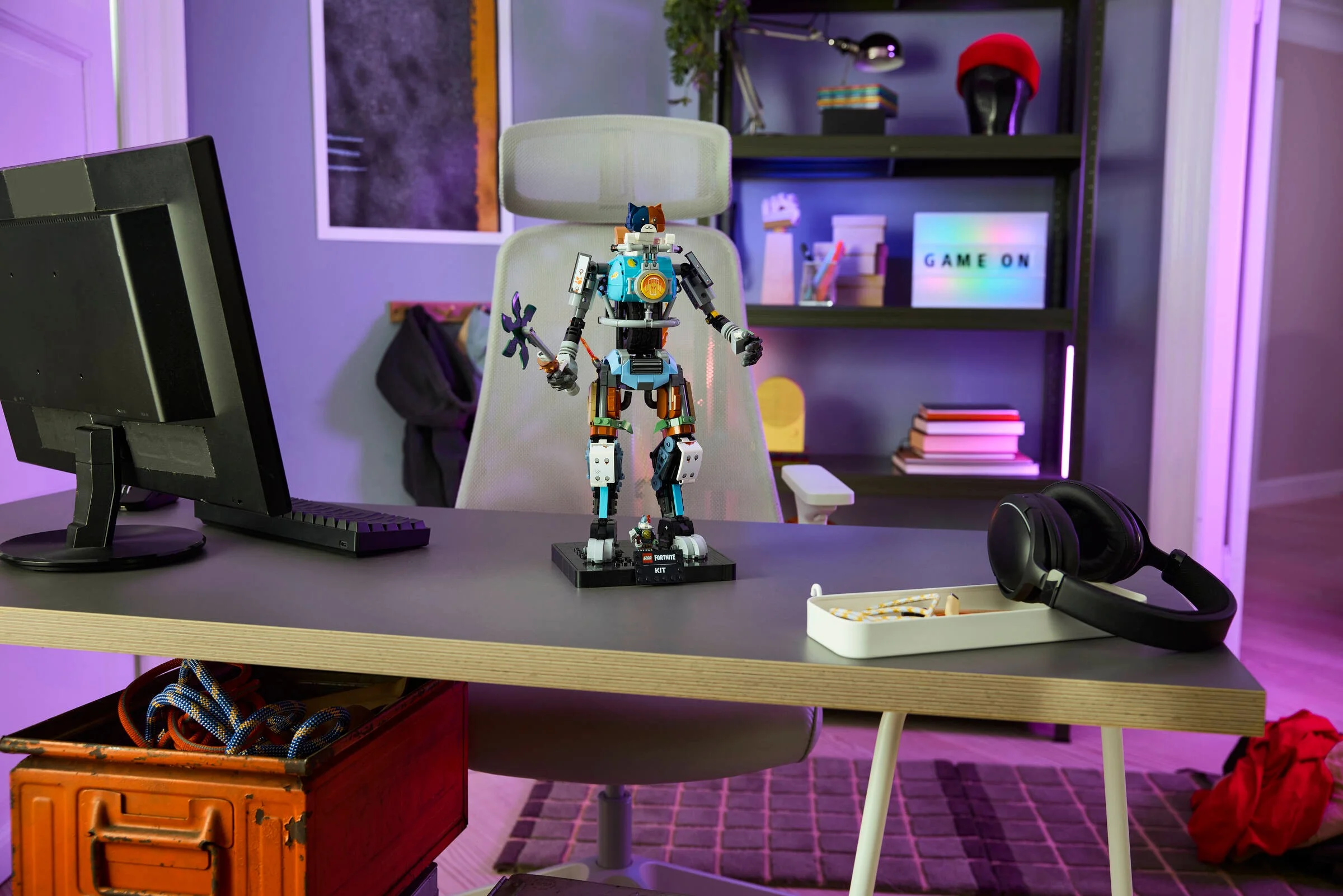 Setul LEGO Fortnite 77081 KIT prezentat într-un setup de gaming. Modelul este pe un birou, într-o cameră cu iluminare ambientală.