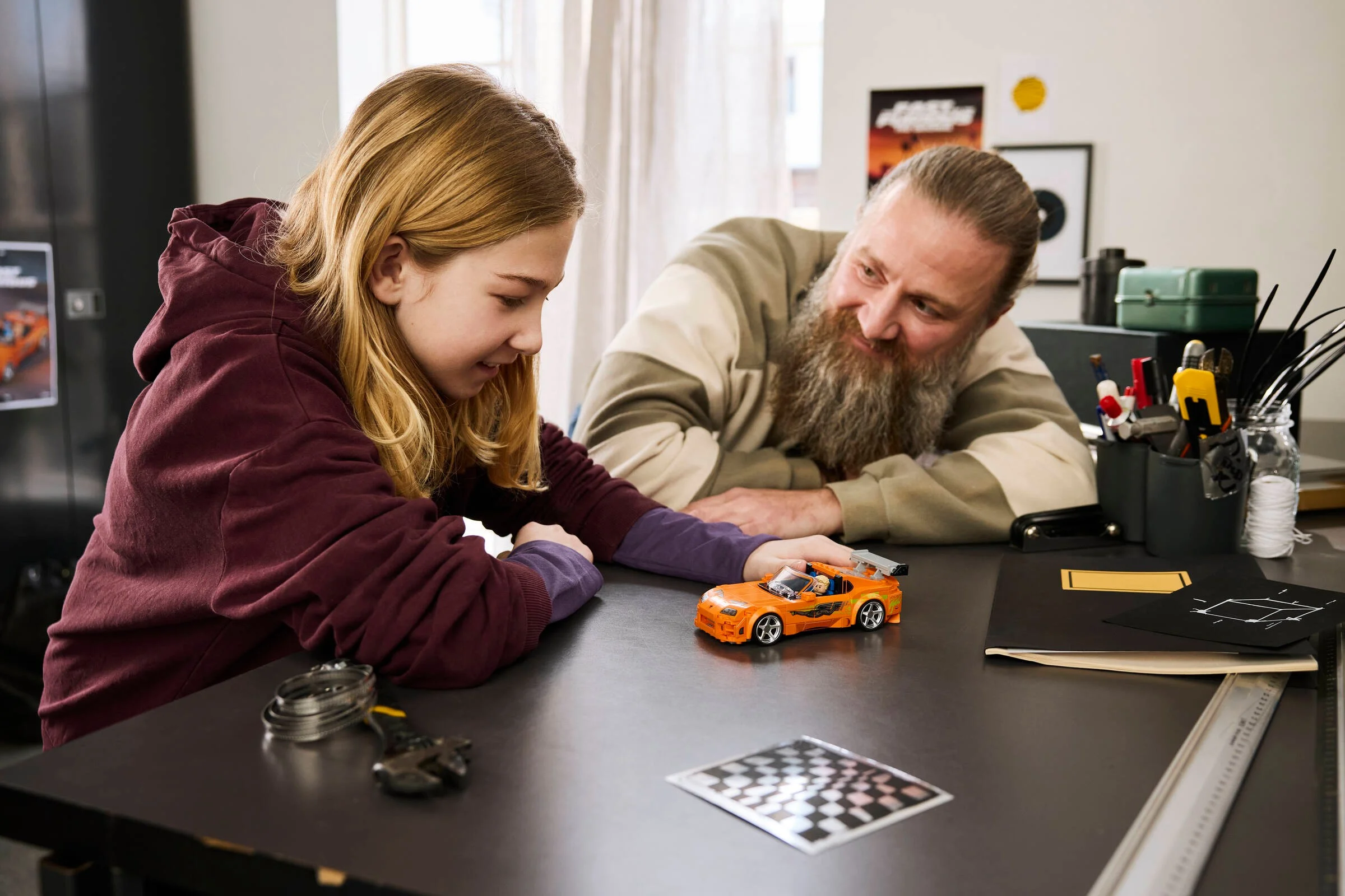Tată și fiică admiră împreună mașina Supra MK4 LEGO. Bucurie și pasiune pentru construit.