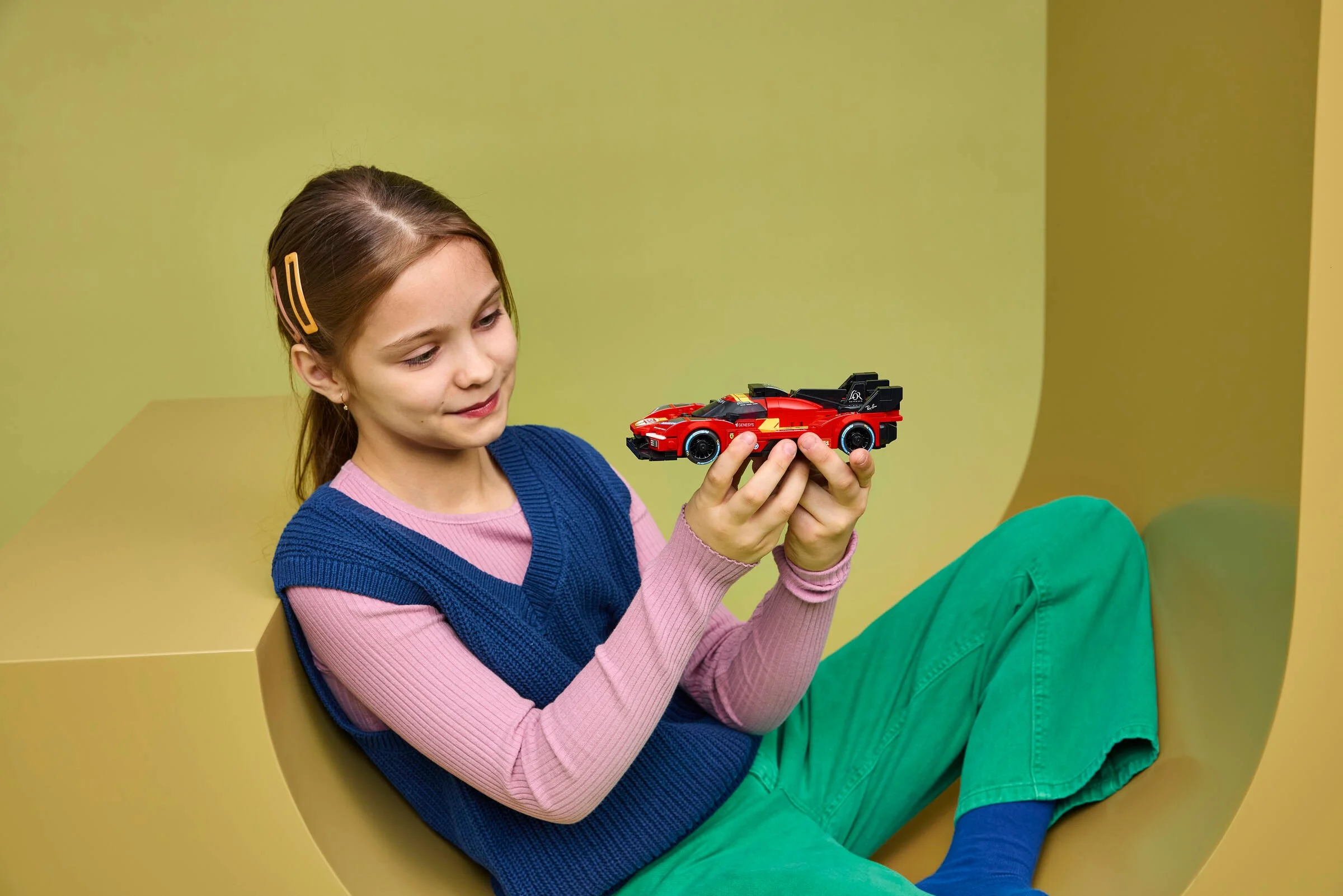 O fetiță admiră modelul LEGO Ferrari 499P. Bucurie și entuziasm!