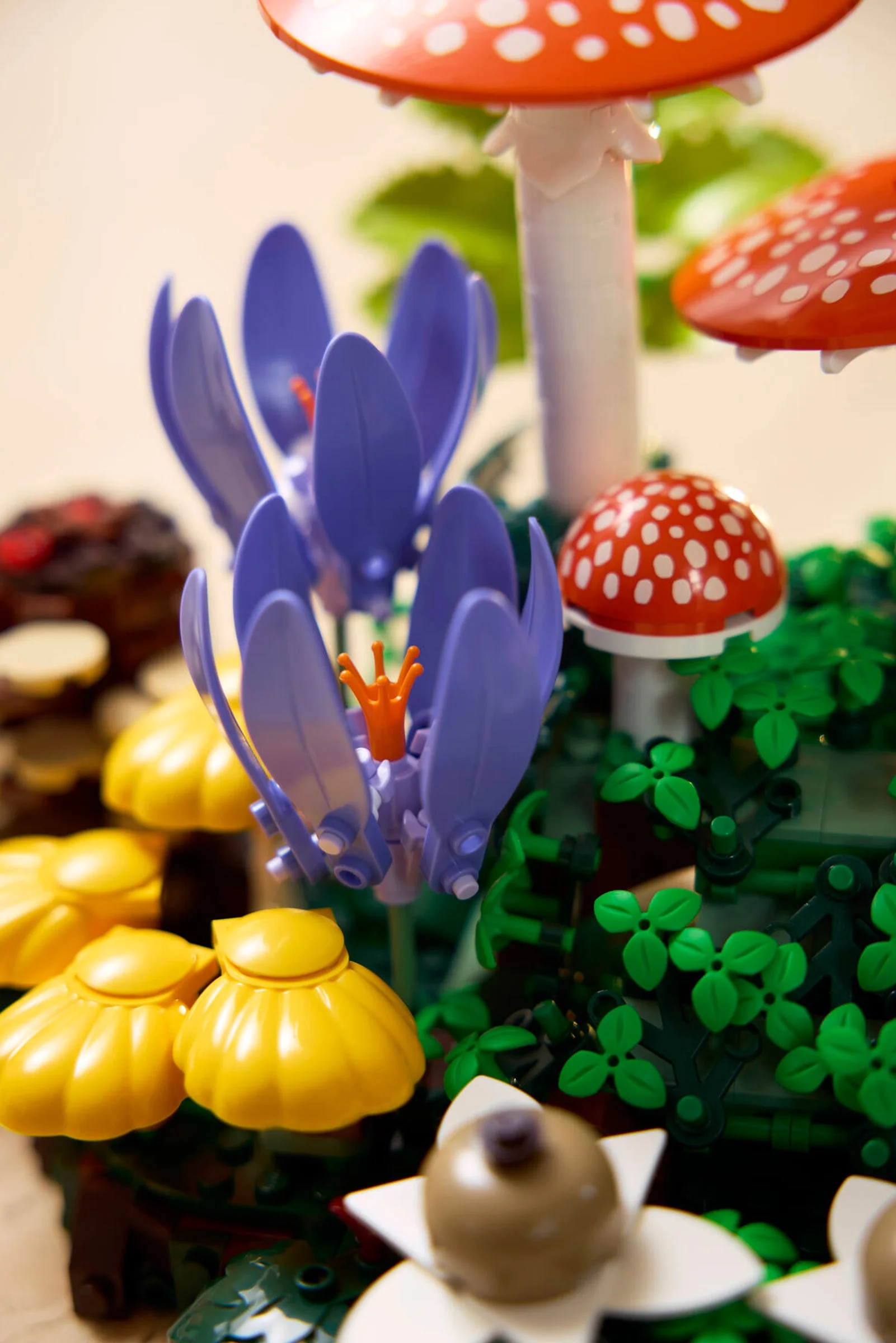 Prim-plan cu diverse ciuperci și flori LEGO din setul Woodland Mushrooms. Culori vii și detalii realiste.