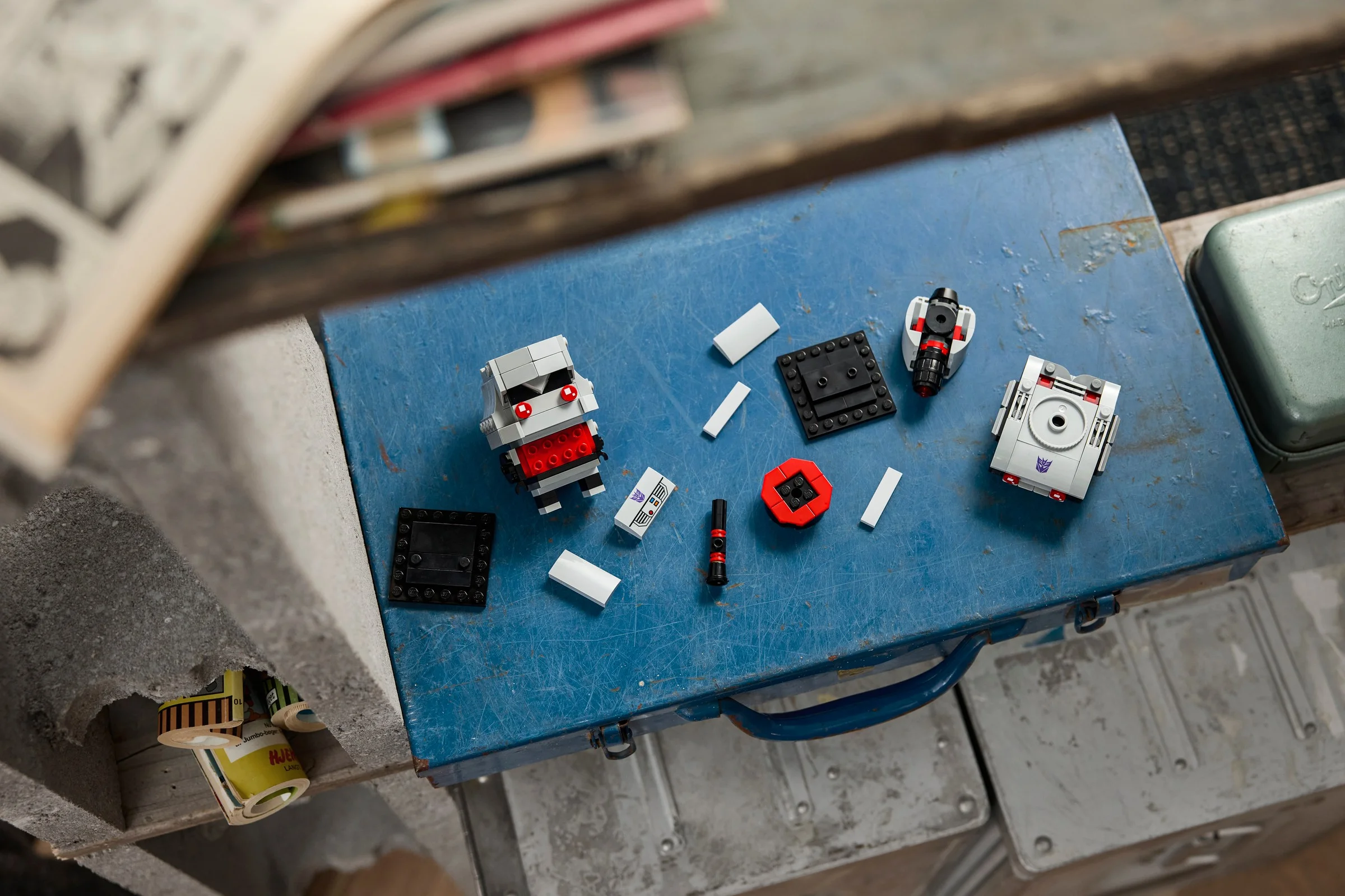 Componente BrickHeadz Megatron aranjate, evidențiind construcția. Piesele includ corpul, accesorii și plăci de bază.