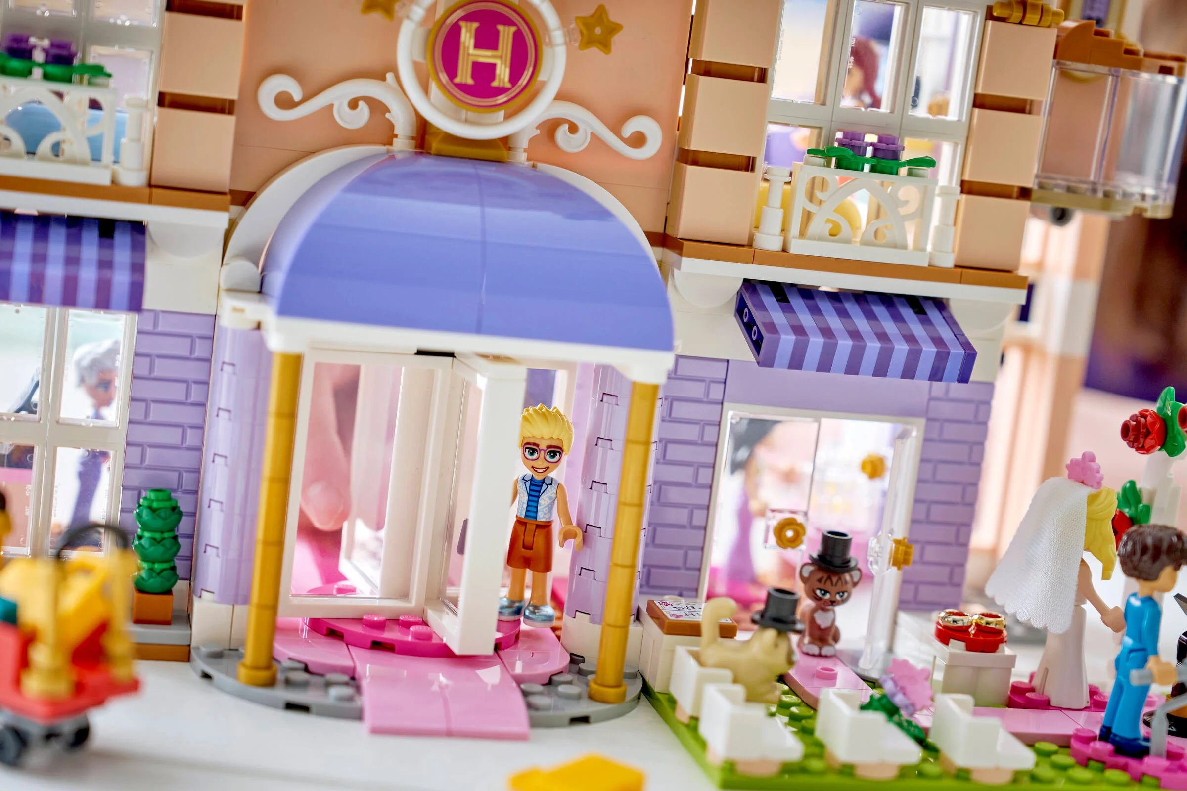 Prim plan cu intrarea hotelului, cu mini-figurine și detalii arhitecturale.
