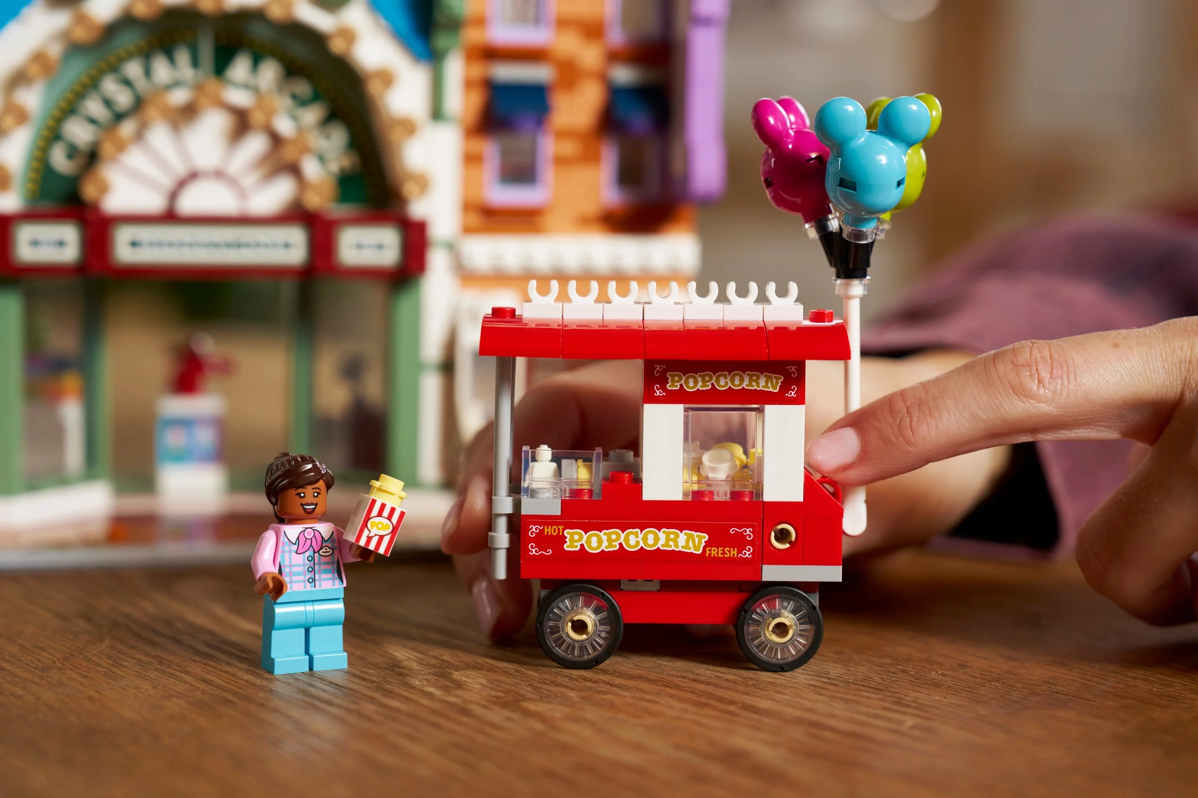 Prim-plan cu minifigurina și căruciorul de popcorn al setului Main Street. Detalii despre atracții.